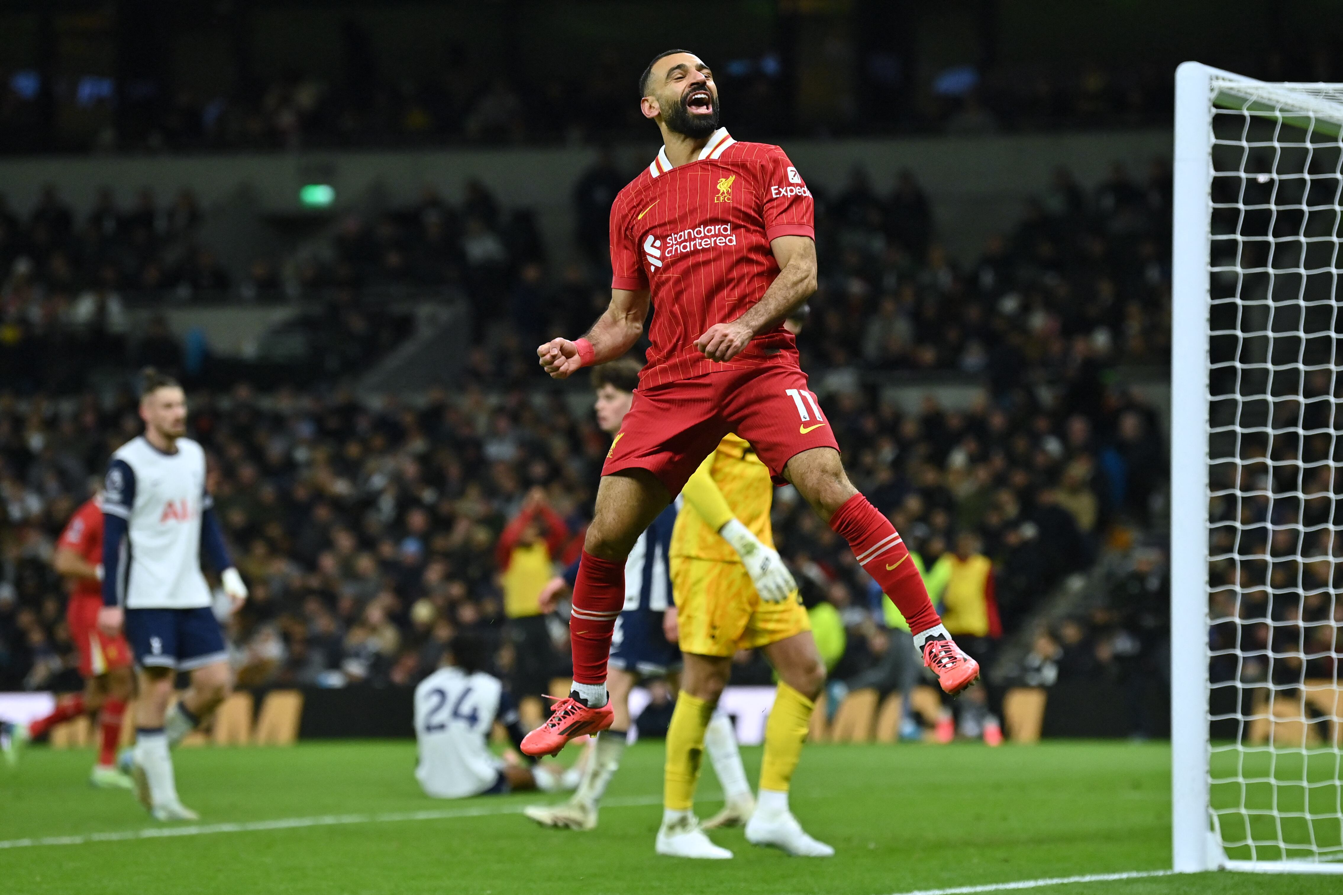 Liverpool's Egyptian striker #11 Mohamed Salah celebrates after scoring their fifth goal during the English Premier League football match between Tottenham Hotspur and Liverpool at the Tottenham Hotspur Stadium in London, on December 22, 2024. (Photo by Glyn KIRK / AFP) / RESTRICTED TO EDITORIAL USE. No use with unauthorized audio, video, data, fixture lists, club/league logos or 'live' services. Online in-match use limited to 120 images. An additional 40 images may be used in extra time. No video emulation. Social media in-match use limited to 120 images. An additional 40 images may be used in extra time. No use in betting publications, games or single club/league/player publications.