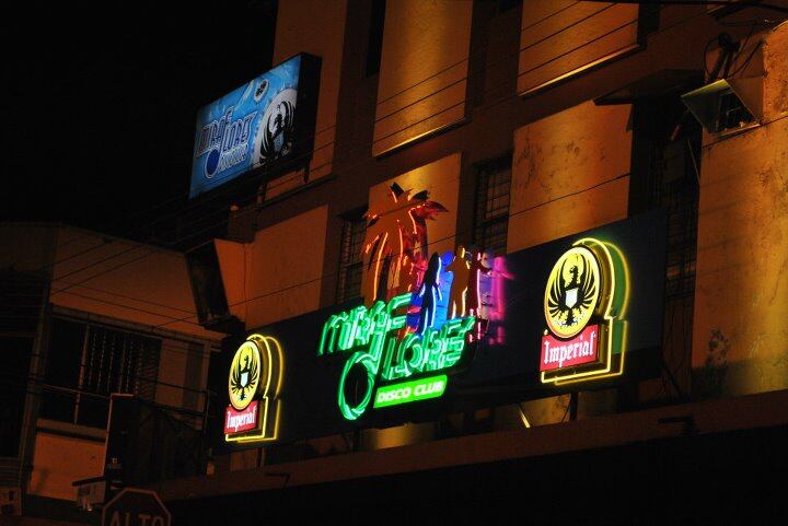 Fachada nocturna de la Discoteca Miraflores en Heredia, con letreros iluminados de neón, anunciando su cierre tras 54 años de operación.