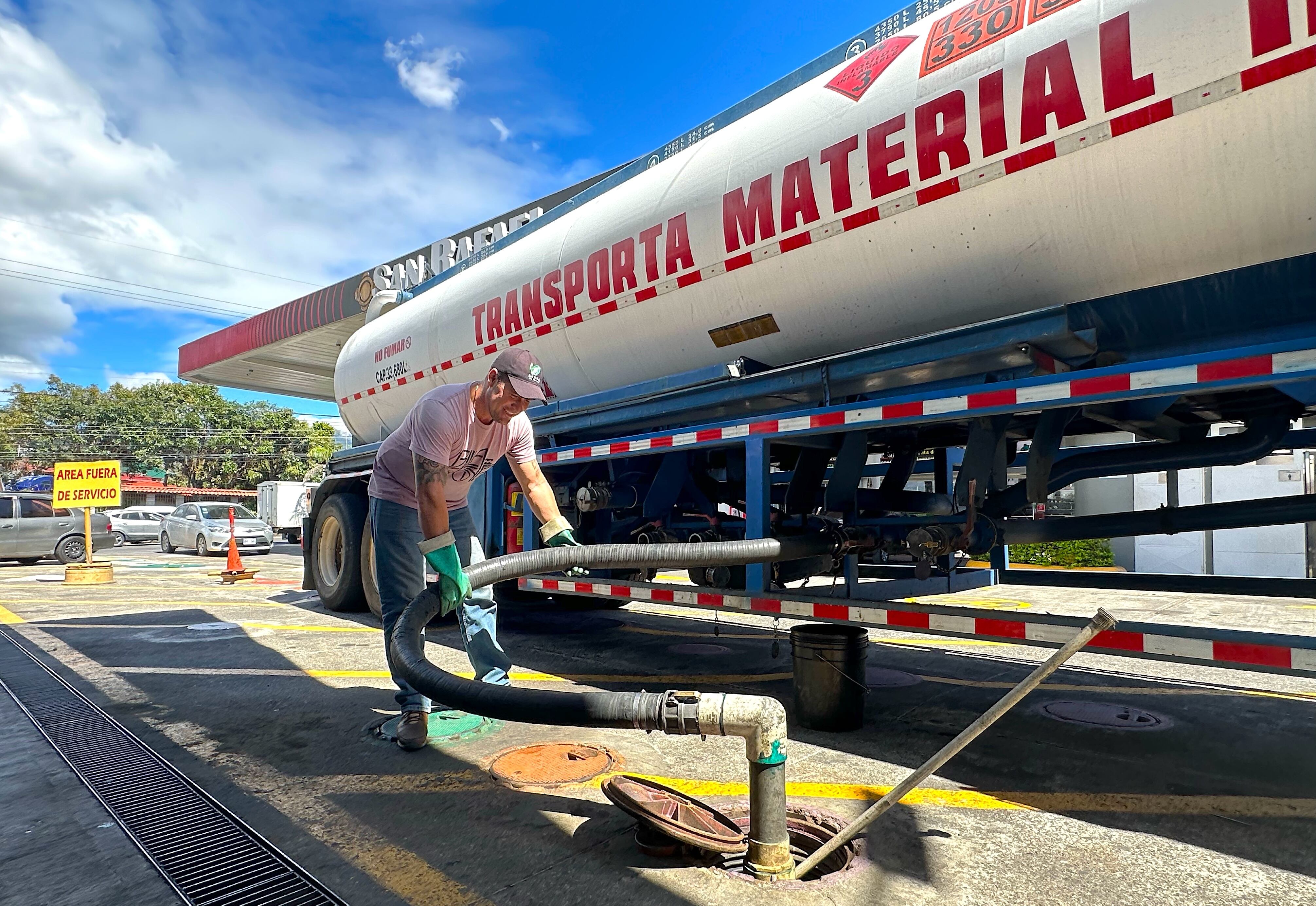 Operario descargando hidrocarburos desde un camión cisterna a los tanques de una gasolinera en Costa Rica. Debido a un ataque informático, Recope realiza las operaciones de venta de carburantes de forma manual.