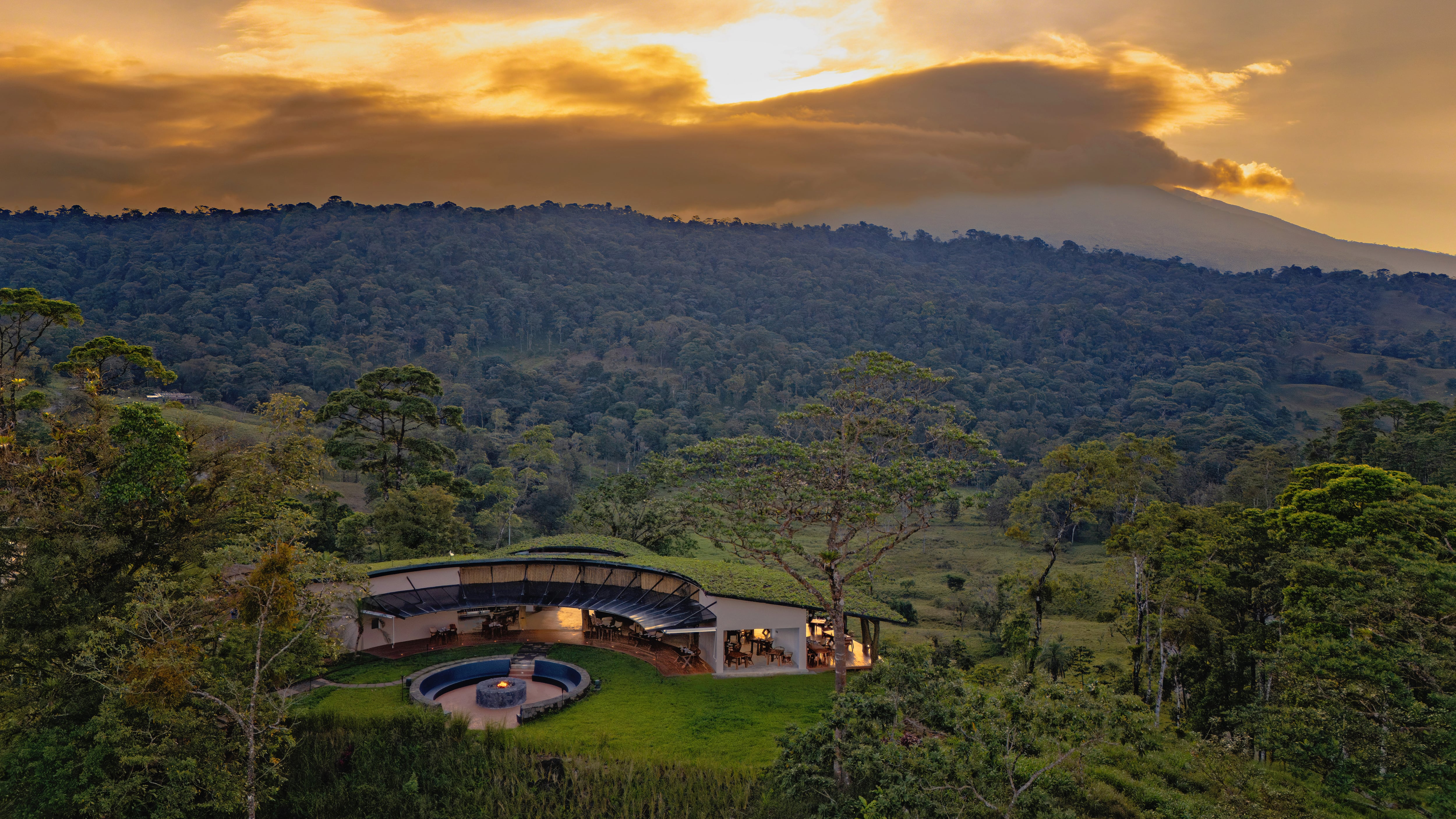 Hotel Origins Astral en Bijagua de Upala rodeado de bosque tropical con restaurante panorámico y fogata central, parte de un resort de lujo cercano al Río Celeste.
