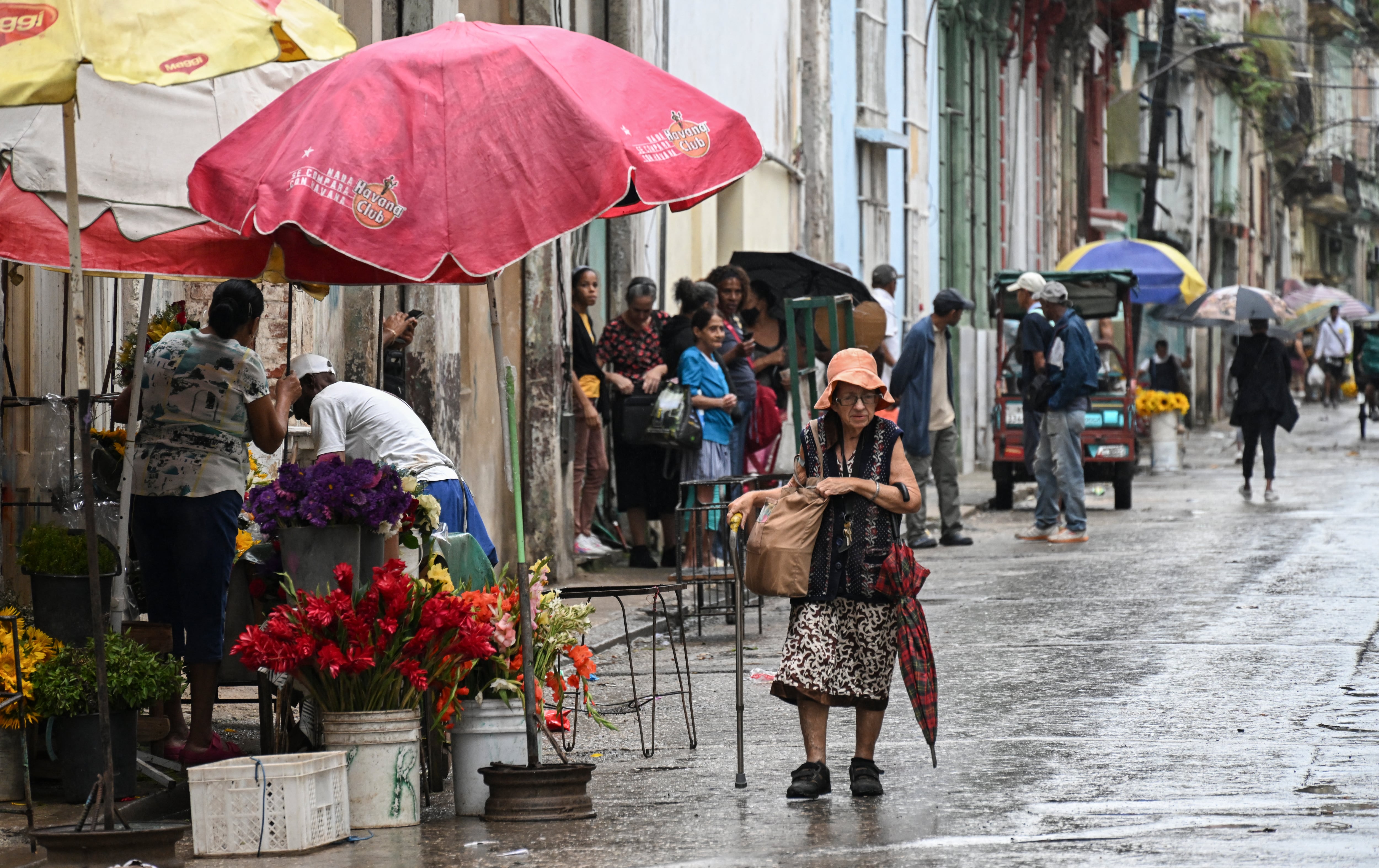 Personas caminan por una calle de La Habana.