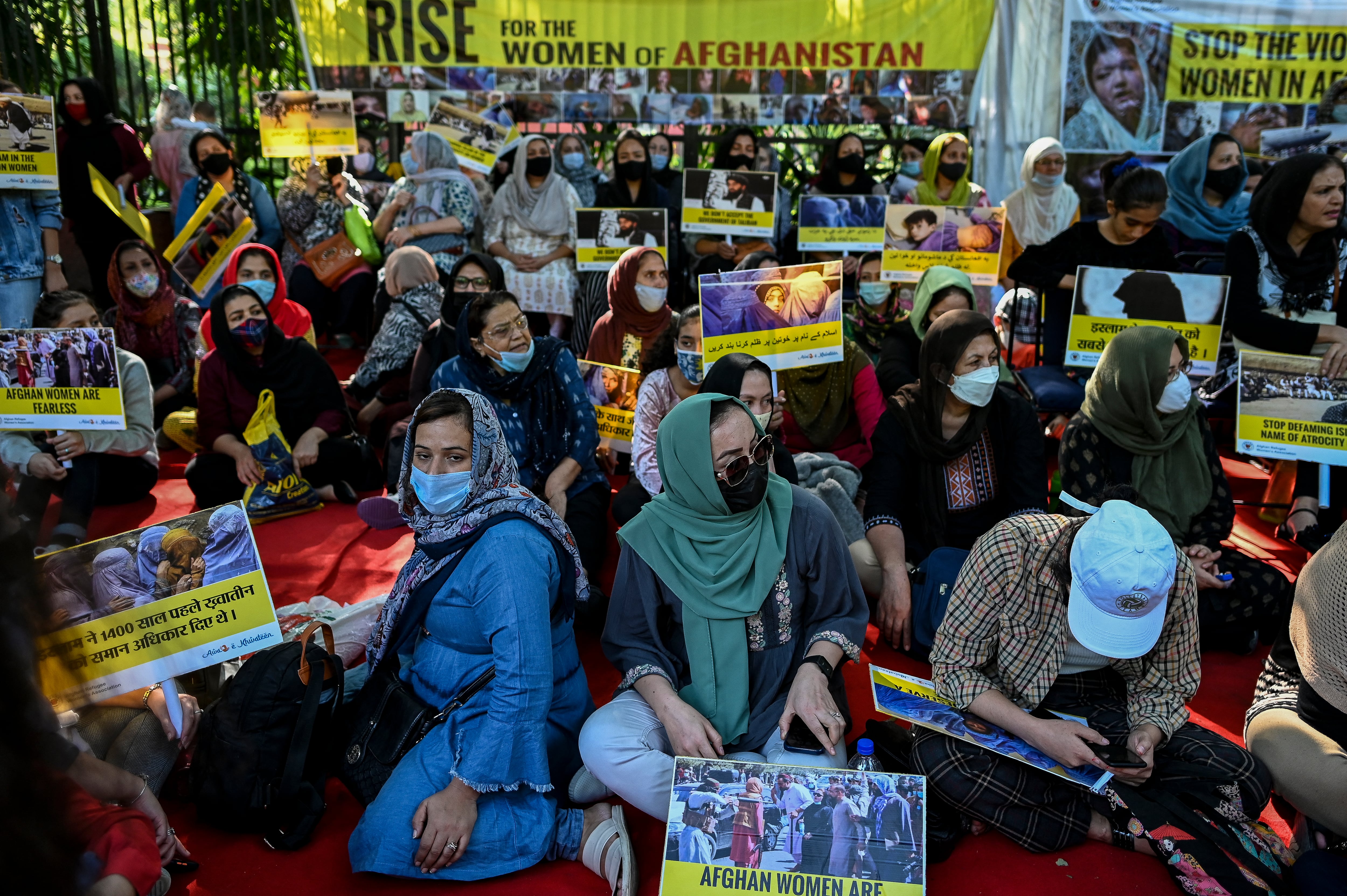 Nacionales afganos que residen en India y simpatizantes de la Asociación de Mujeres Refugiadas Afganas sostienen pancartas y carteles y gritan consignas durante una manifestación en Nueva Delhi el 30 de octubre de 2021 para exigir mejores derechos para las mujeres en Afganistán