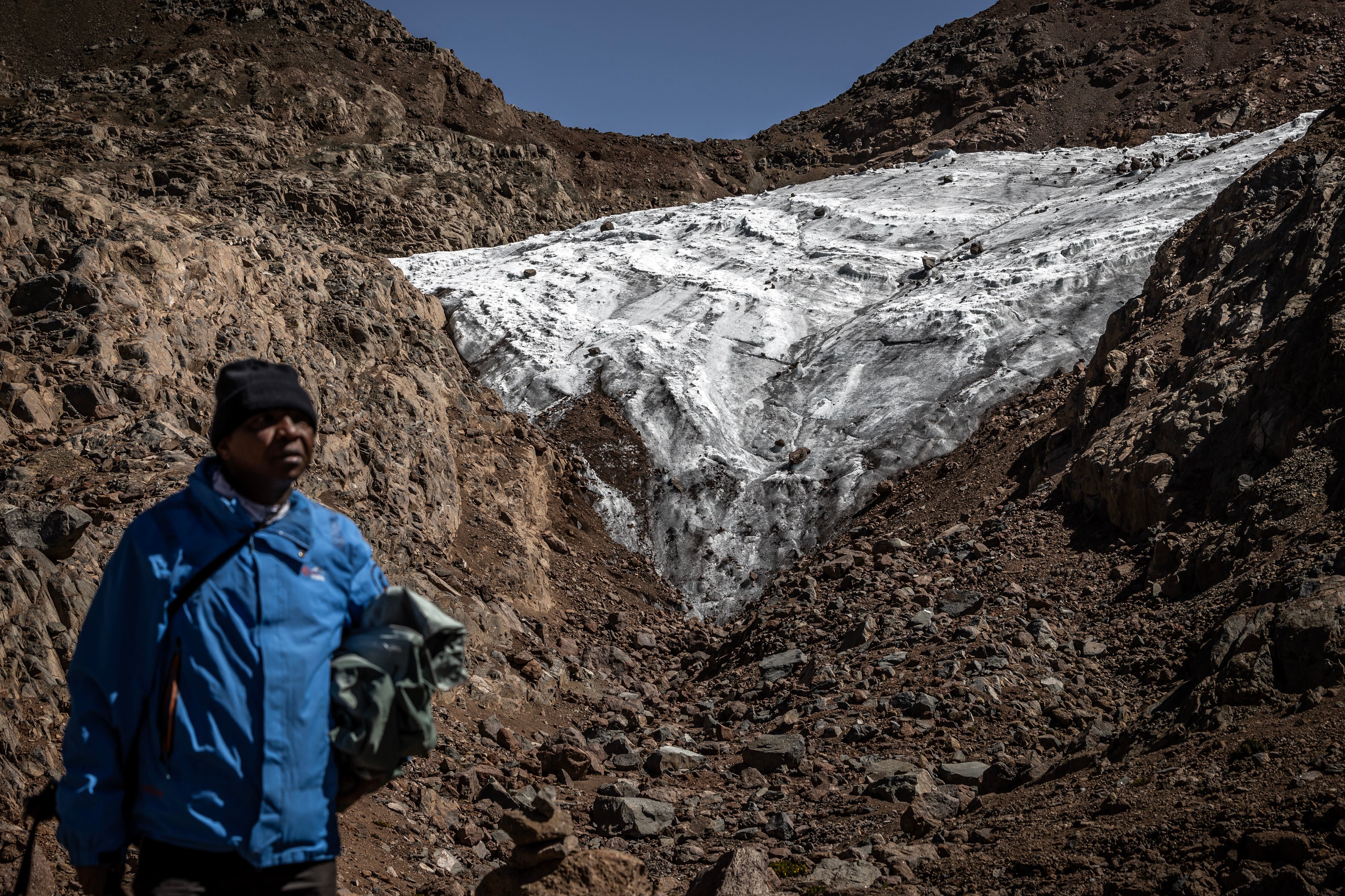 Professional mountaineer guide Charles Kibaki Muchiri, 50, observes the landscape beside Lewis Glacier, near the summit of Mount Kenya, inside Mount Kenya National Park, on March 7, 2025. Mount Kenya, Africa's second-highest peak, is home to rapidly shrinking gla
