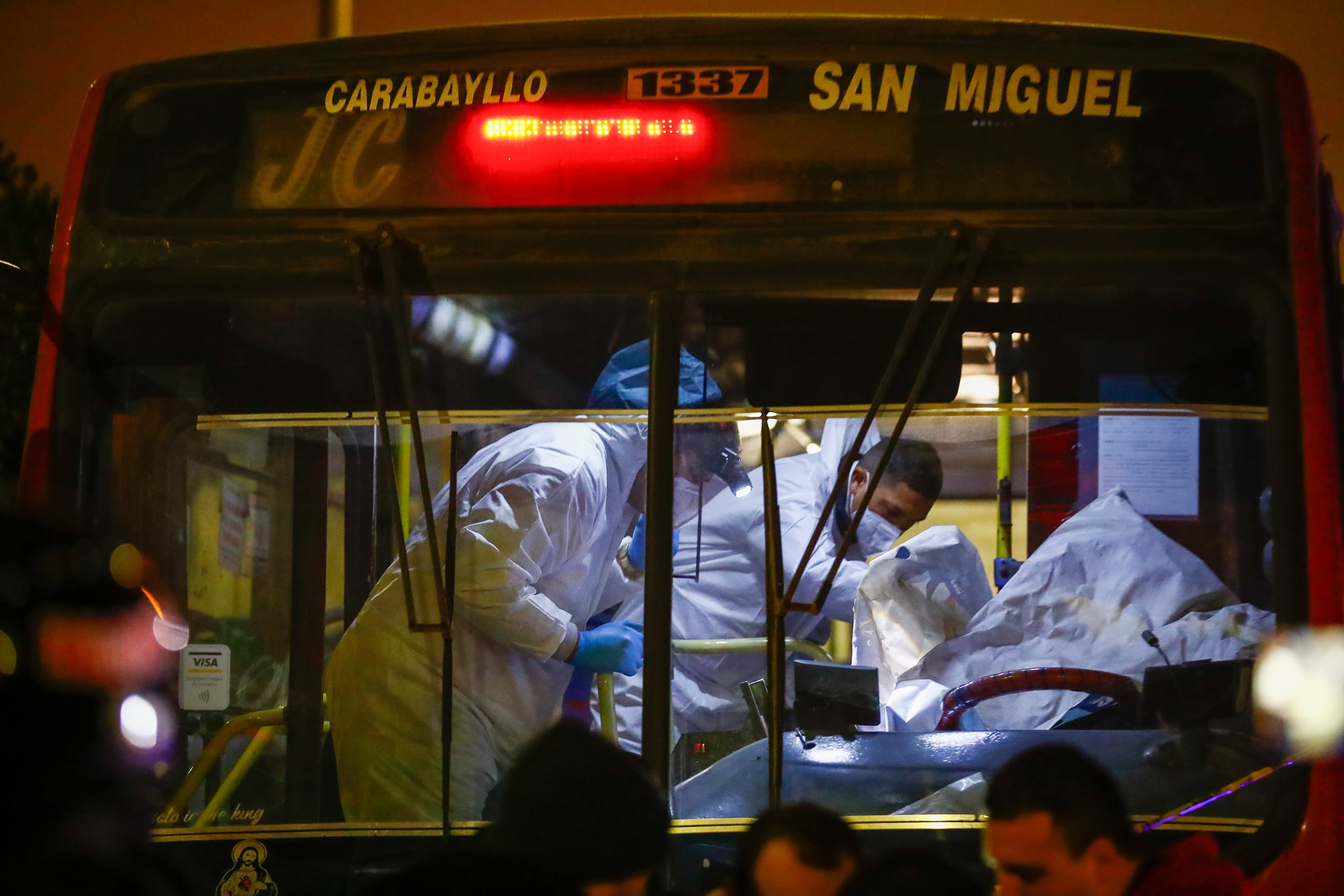 Fotografía tomada en el distrito de Los Olivos en Lima, que nos muestra la escena de un chofer asesinado producto de la ola de extorsión y sicariato, que sigue ganando terreno en el Perú, según cifras oficiales. Es una imagen que resume la violencia diaria que sufren los choferes de transporte público y que captura inmediatamente la atención del lector ante una escena que aunque cotidiana en las calles del Perú, no deja de impactar por su crudeza.