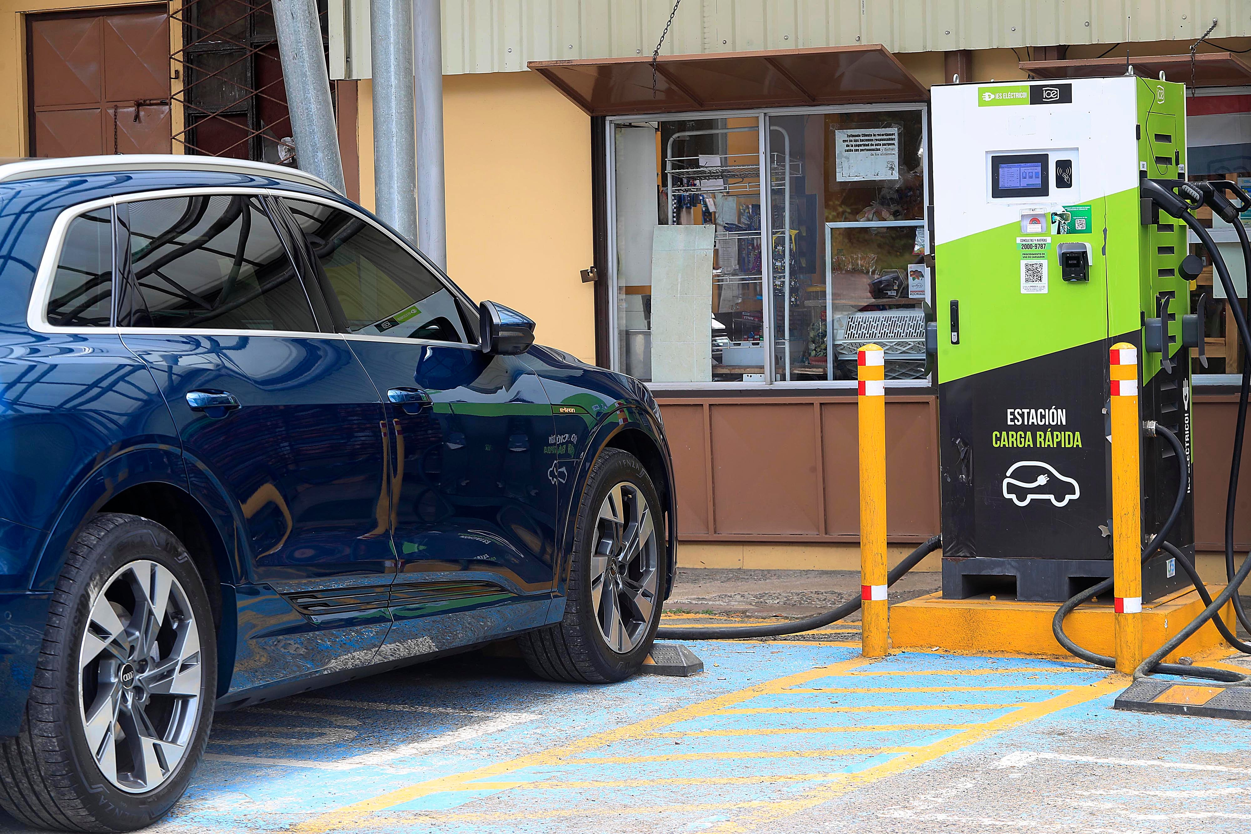 Automóvil eléctrico color azul cargando en una estación de carga rápida en el restaurante Chespiritos 1, ubicado en Ojo de Agua, El Guarco, sobre la carretera Interamericana Sur. La imagen refleja la importancia de mejorar la infraestructura de carga en Costa Rica.