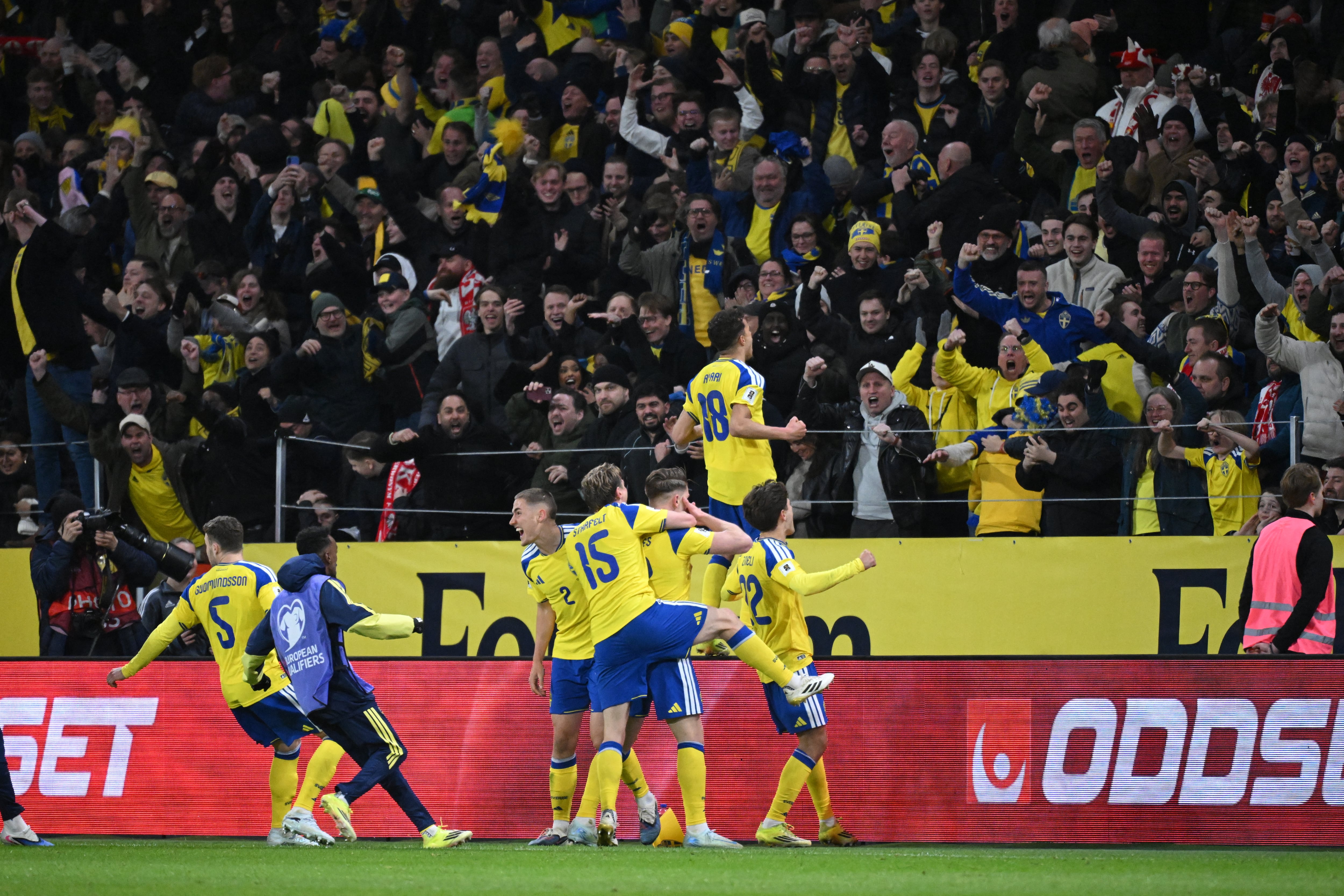 El delantero Viktor Gyokeres celebra con compañeros y aficionados el gol que les dio la clasificación al Mundial 2026 ante Polonia.