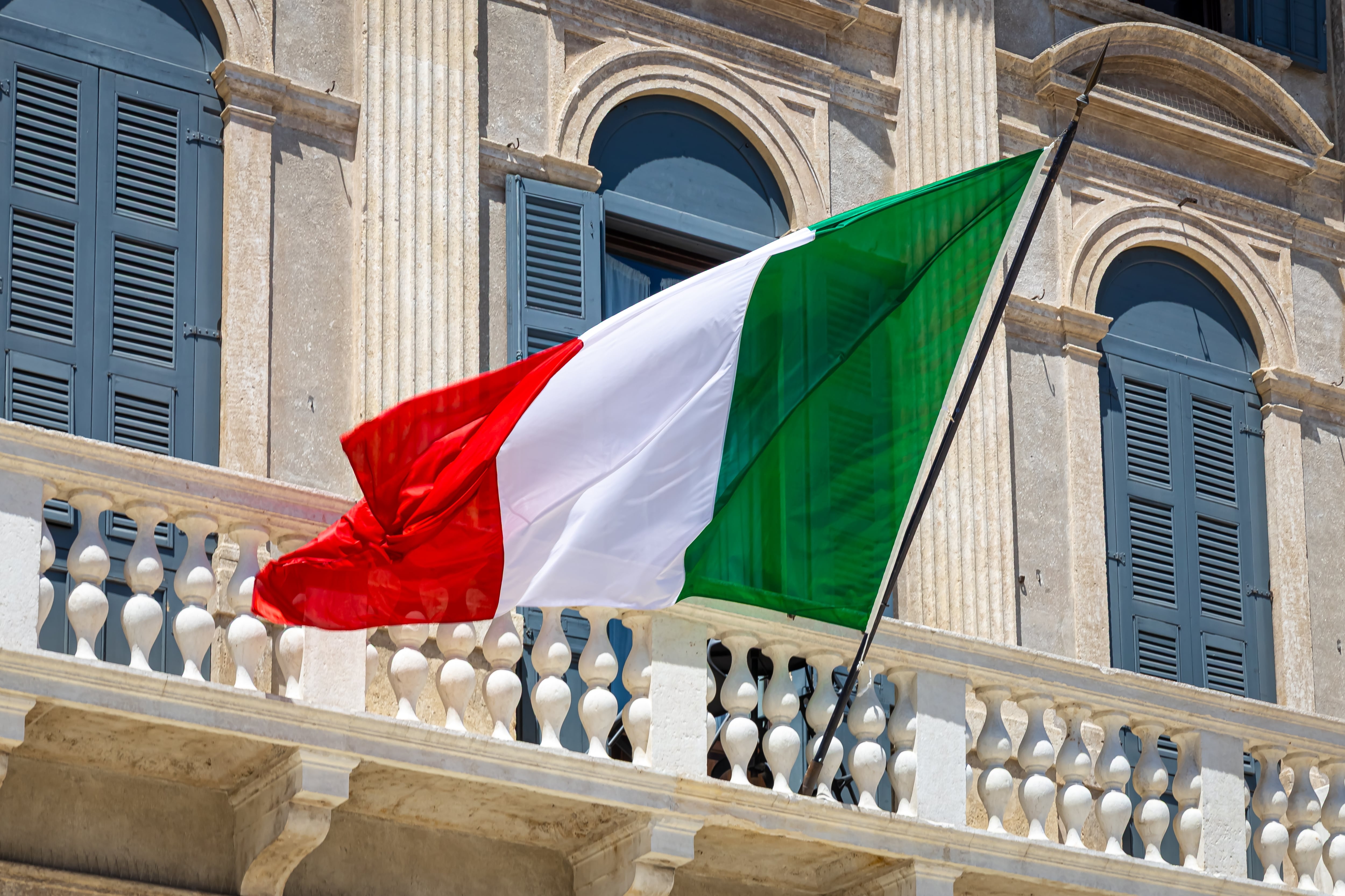 Bandera de Italia ondeando en balcón de edificio