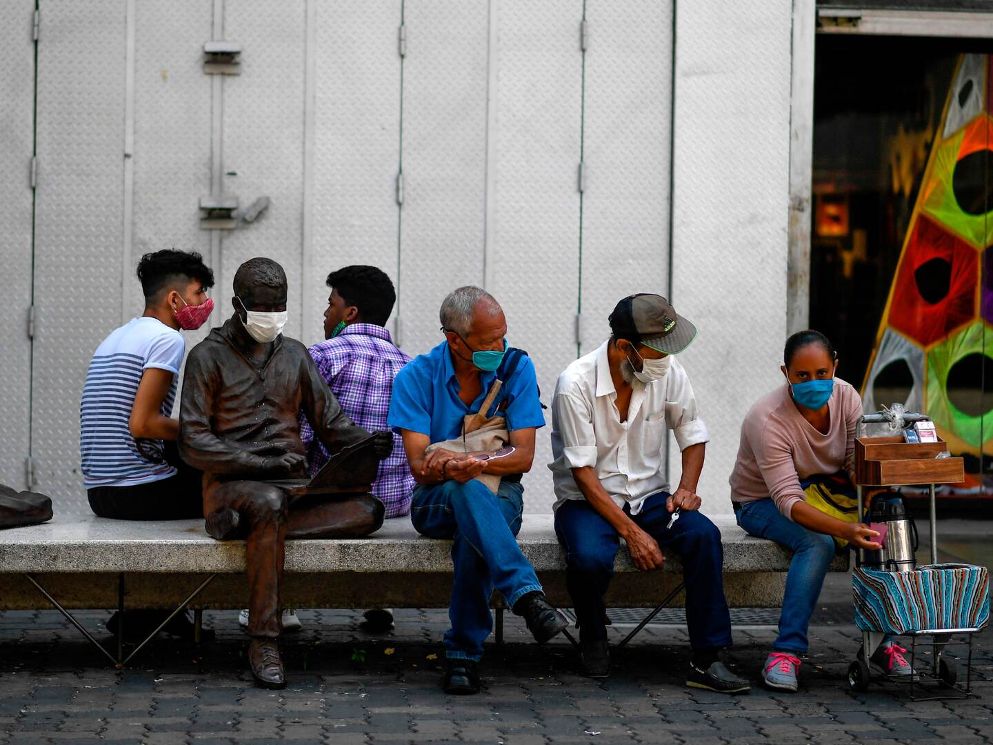 People wear face masks as they rest on Sabana Grande's Boulevard after the government eased a nationwide lockdown as a preventive measure against the COVID-19 coronavirus, in Caracas, on June 3, 2020. - Banks, shoe stores and hairdressers reopened this week in Venezuela in a relaxation of the quarantine in force since mid-March due to the COVID-19 pandemic, coinciding with kilometer-long lines of vehicles waiting for turns at gasoline pumps. (Photo by Federico PARRA / AFP)