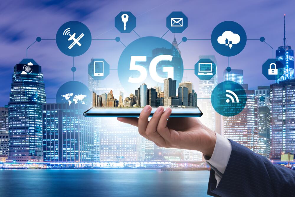 Mano sostiene un plano a escala de una ciudad conectada con íconos de tecnología.