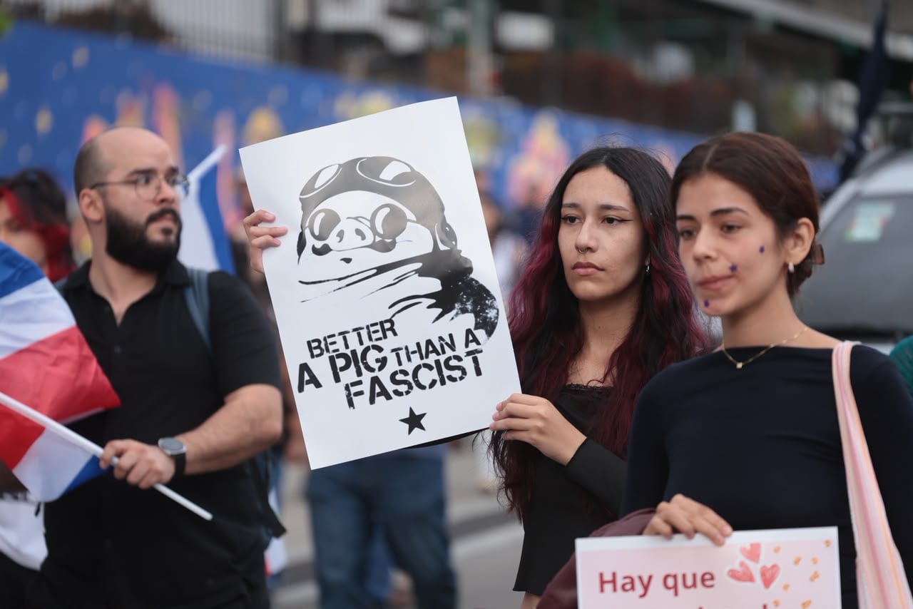 Cientos de personas con carteles y banderas se dirigen al Plantón por la Justicia Democrática en la plaza de la Democracia en San José.