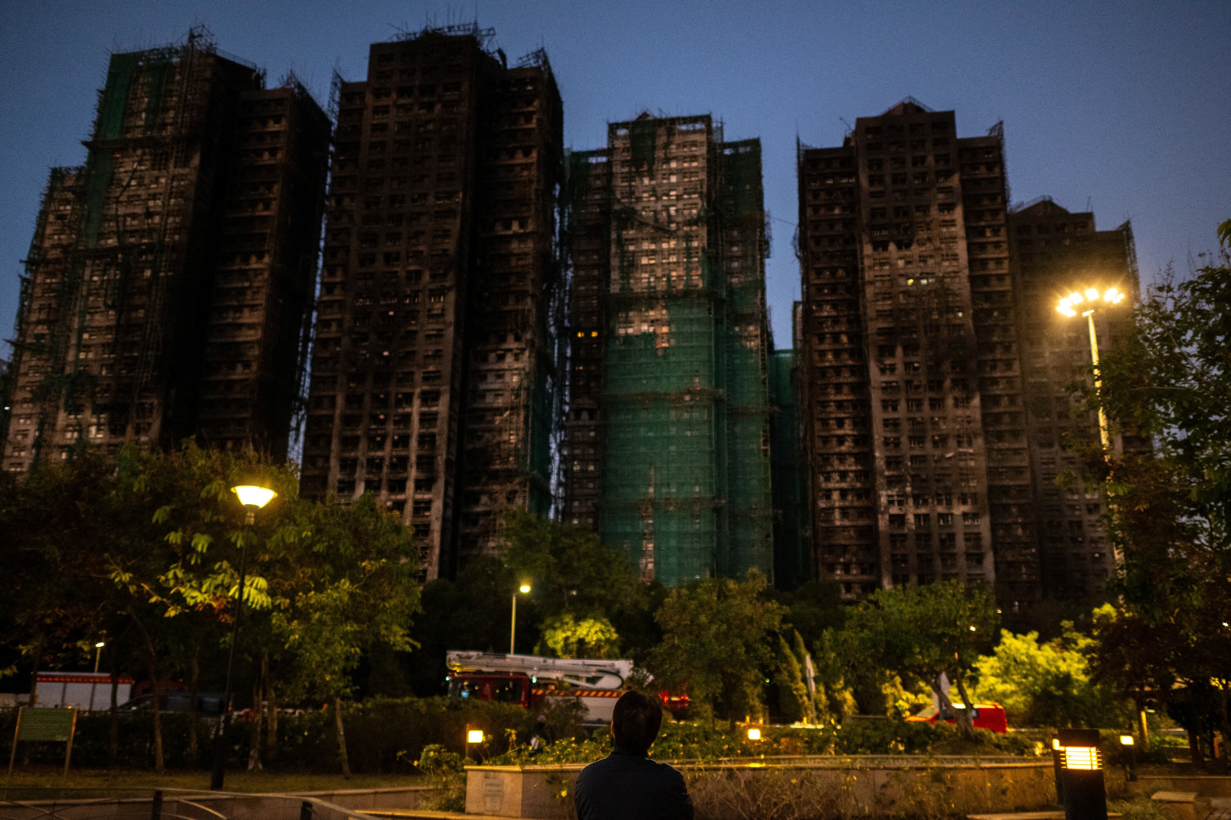 Un hombre este viernes frente a las consecuencias del gran incendio que arrasó varios bloques de apartamentos en la urbanización Wang Fuk Court, en el distrito Tai Po de Hong Kong. Fotografía: