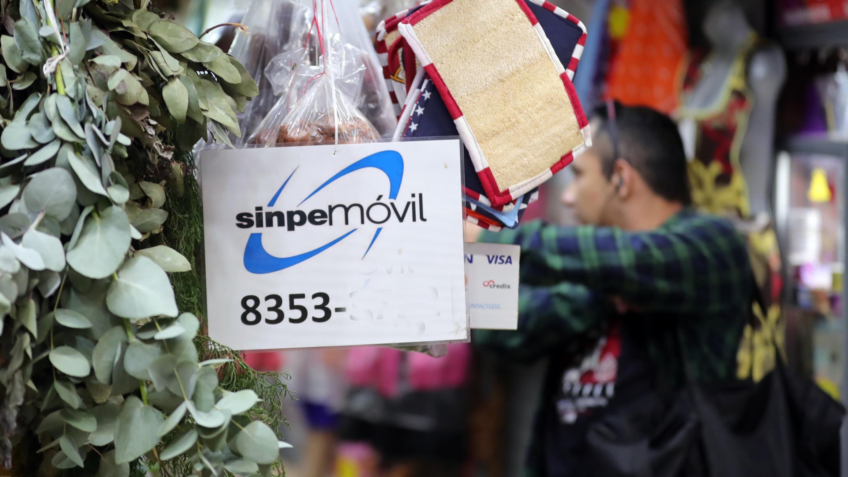 En la imagen, la vista de productos y un letrero promocionando Sinpe Móvil en un comercio local.