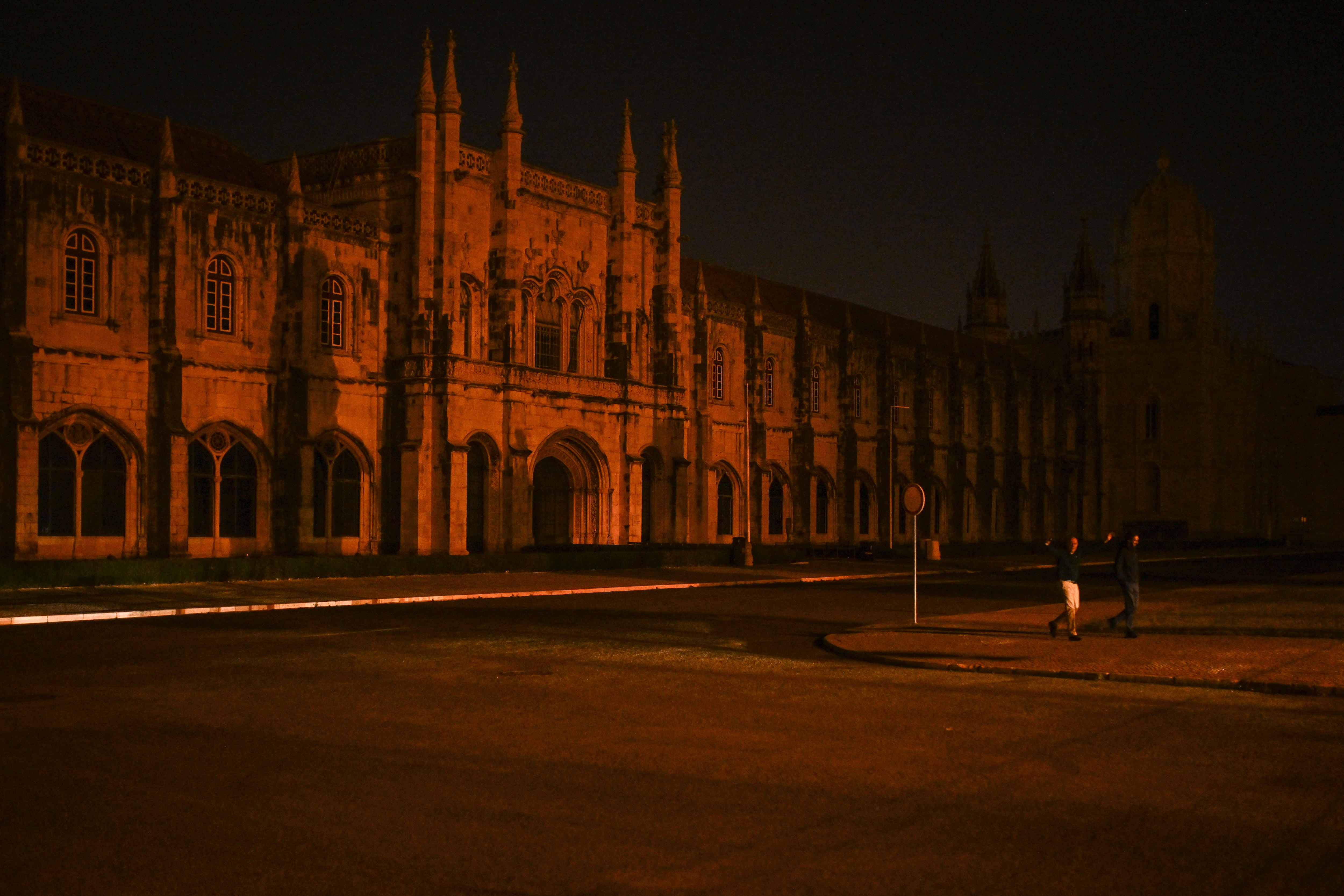 People walk at night in Barcelona, without electricity, following a massive power cut affecting the entire Iberian peninsula and the south of France, on April 28, 2025. A "massive" power cut late on April 28, 2025 morning affected the whole of the Iberian peninsula and part of France, according to Portuguese electricity network operator REN. (Photo by Josep LAGO / AFP)