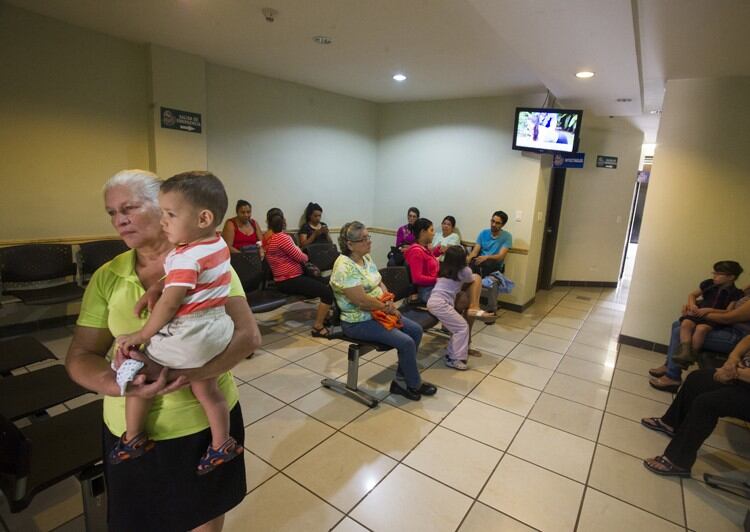 Un grupo de gente en la sala de espera de una clínica.