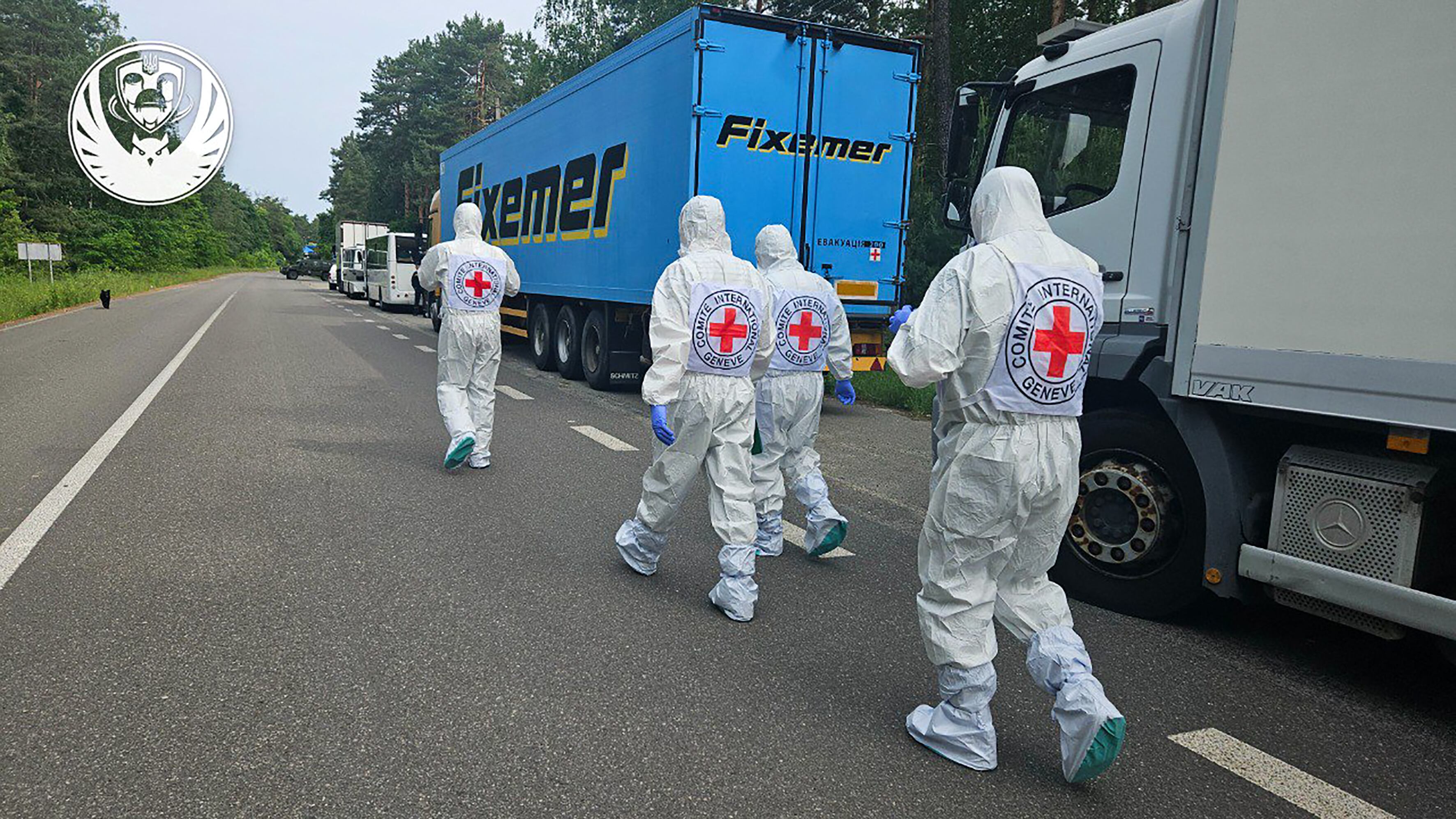 Representantes de la Cruz Roja Internacional este 11 de junio junto a la caravana de frigoríficos del convoy que transportaba los cadáveres de soldados ucranianos, en medio de la invasión rusa de Ucrania. Fotografía:
