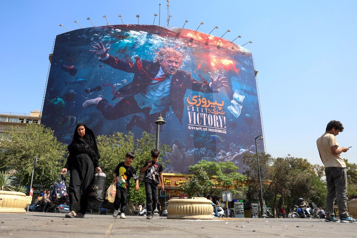 Personas pasan frente a una valla publicitaria antiestadounidense en Teherán, el 24 de agosto de 2026. Irán respondió con desafío este 24 de agosto a una amenaza de Estados Unidos de lanzar «la mayor ofensiva financiera de la historia».