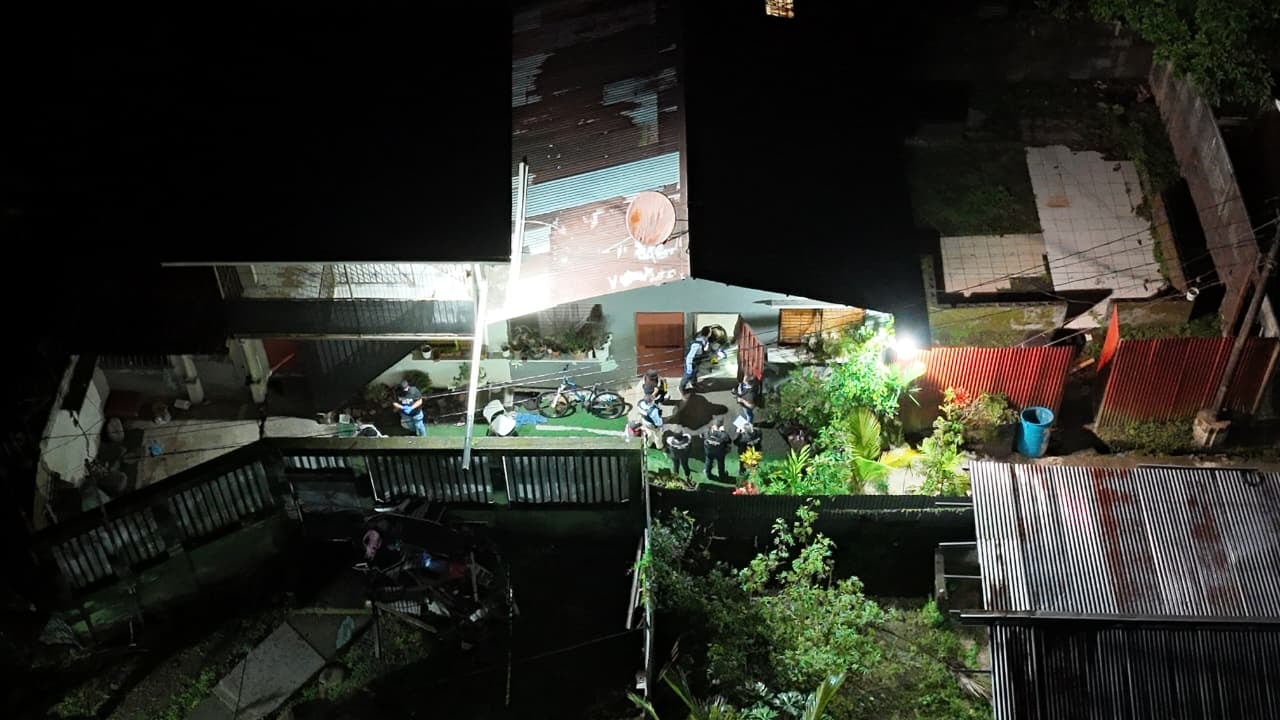 Agentes del OIJ y oficiales de la Fuerza Pública custodian un apartamento en Barrio Realengo, en Guápiles, durante el allanamiento vinculado a una investigación por tentativa de homicidio.