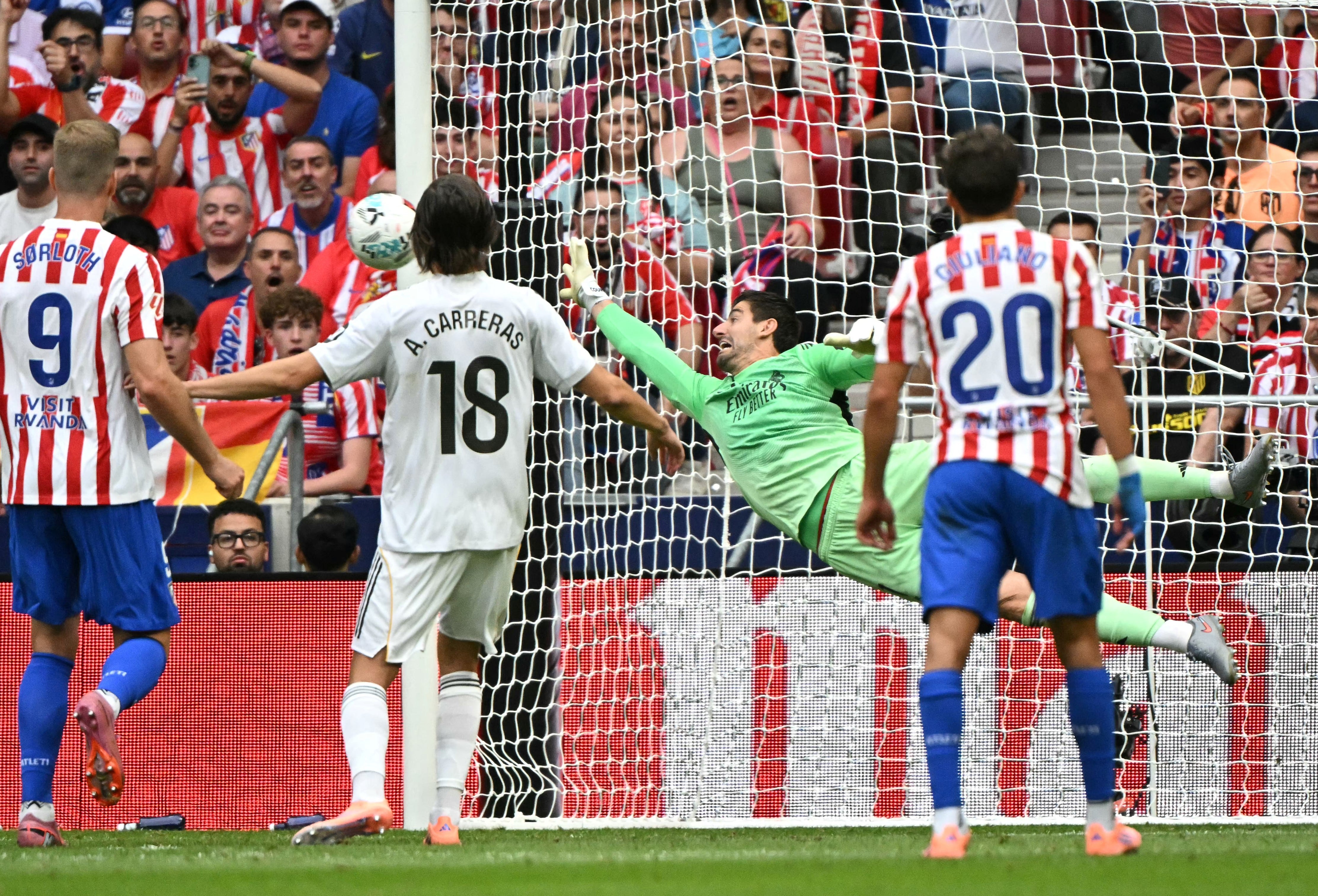 El delantero del Atlético de Madrid Julian Álvarez anota el cuarto gol de su equipo ante el Real Madrid, pese al esfuerzo de Thibaut Courtois, durante el encuentro por la Liga Española en el Estadio Metropolitano.