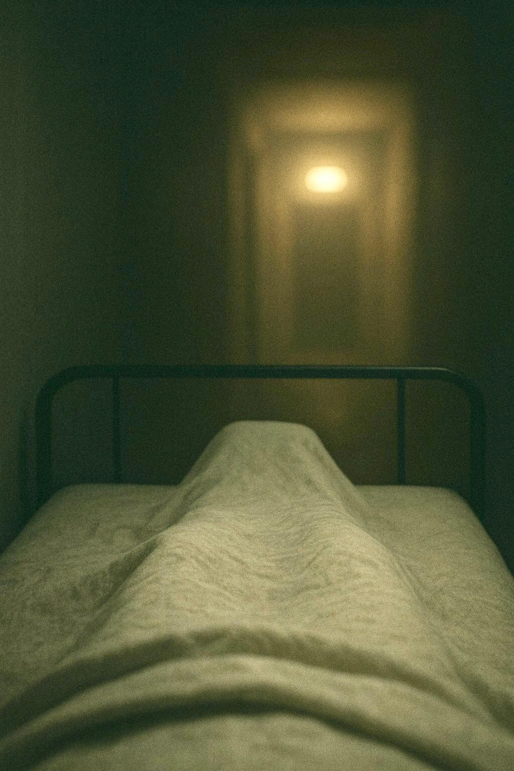 Cama y luz distante en sombras