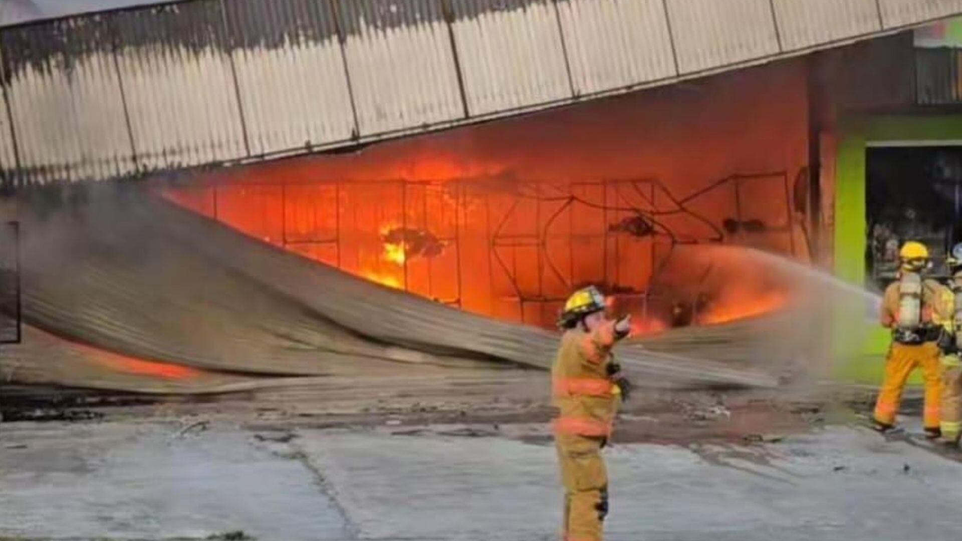 El Cuerpo de Bomberos atiende un incendio en un local comercial.