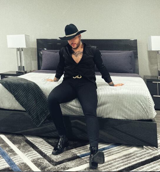 Jessi Uribe posando sentado en una cama