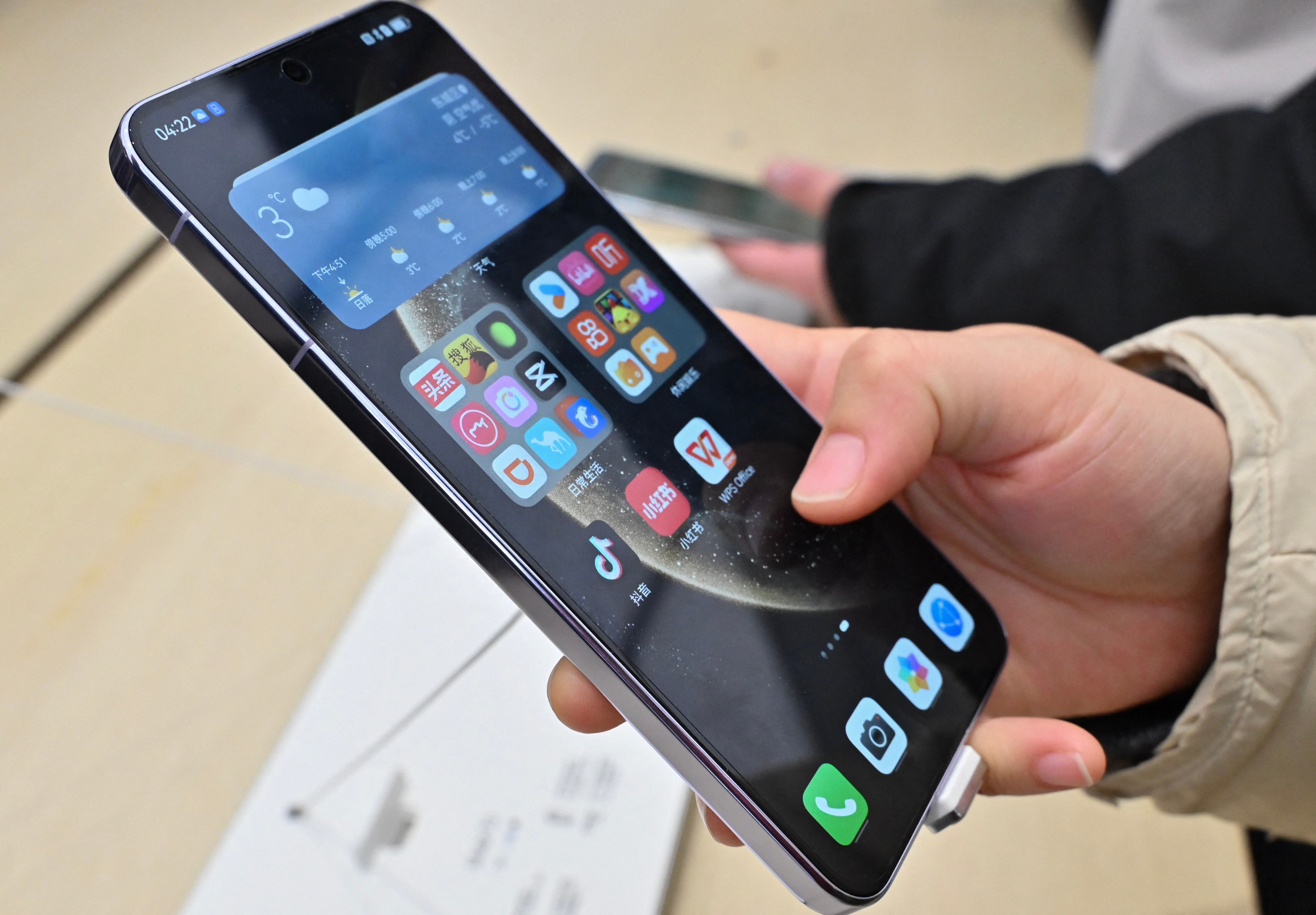 Clientes observando el nuevo Huawei Mate 70 en un comercio del área Wangfujing en Beijing, noviembre 2024. El teléfono cuenta con un sistema operativo creado íntegramente por Huawei.