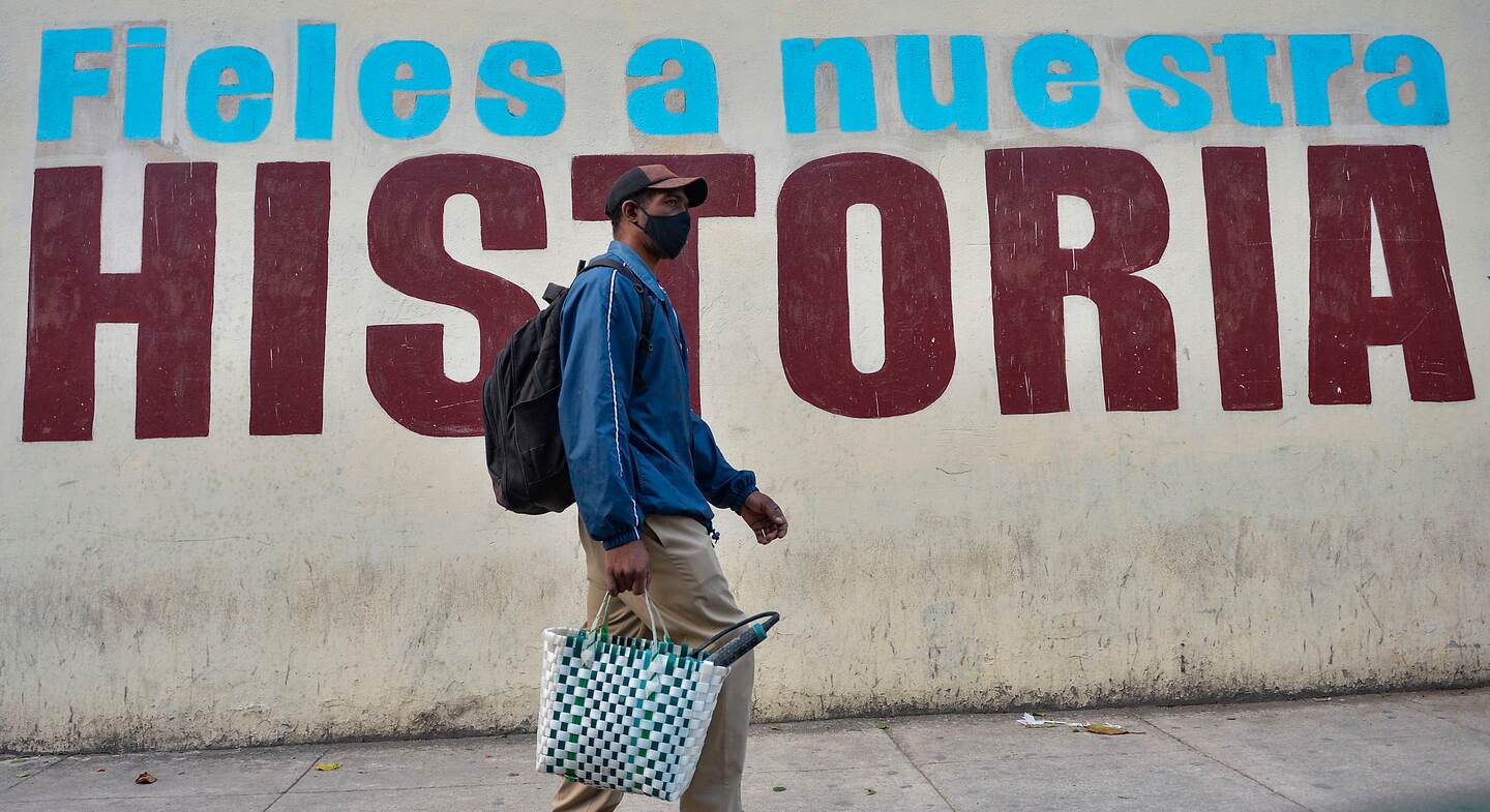 A man wearing a face mask walks in Havana, on February 2, 2021, as COVID-19 cases surge in the island nation. - Cases in Cuba, one of least-affected nations in the region by the coronavirus pandemic, have been surging in recent days. (Photo by Yamil LAGE / AFP)