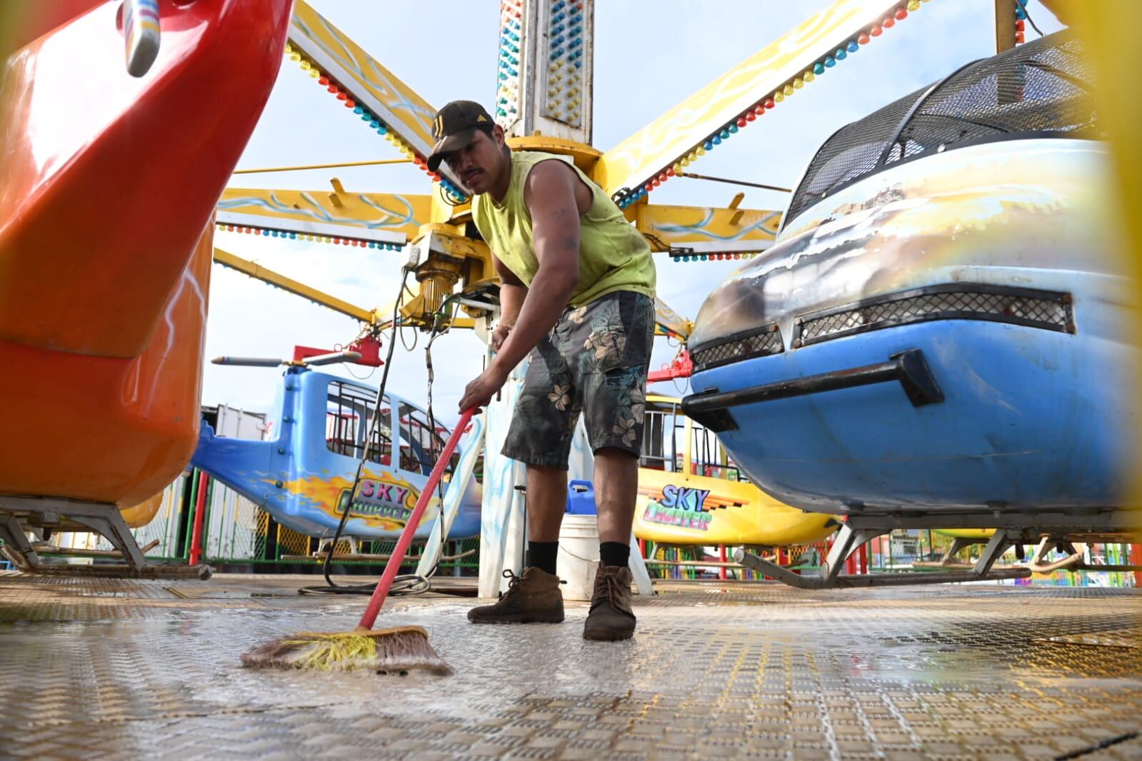 Un hombre limpiando el piso de un juego mecánico.