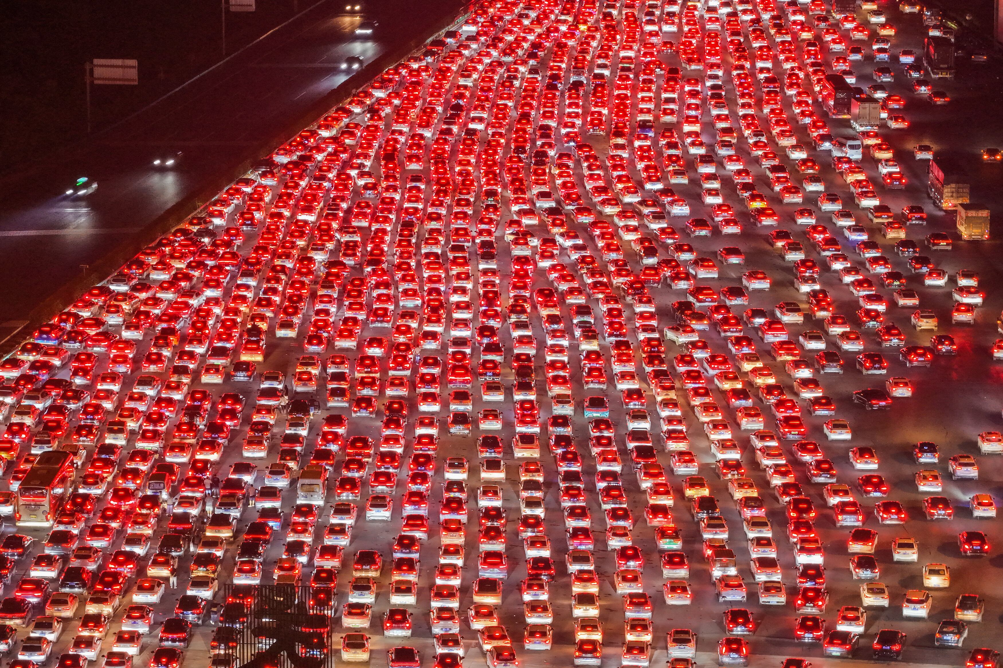 Conductores esperan para pasar por la estación de peaje de Wuzhuang, en una autopista en Chuzhou, en la provincia oriental de Anhui, China, mientras regresaban a casa en el penúltimo día del feriado de ocho días por el Día Nacional, el 7 de octubre de 2025. La estación de peaje de Wuzhuang, ubicada en la frontera entre las provincias de Anhui y Jiangsu, es la más grande de China en autopistas, con un total de 36 carriles. (Foto: AFP) / Prohibida su distribución en China.