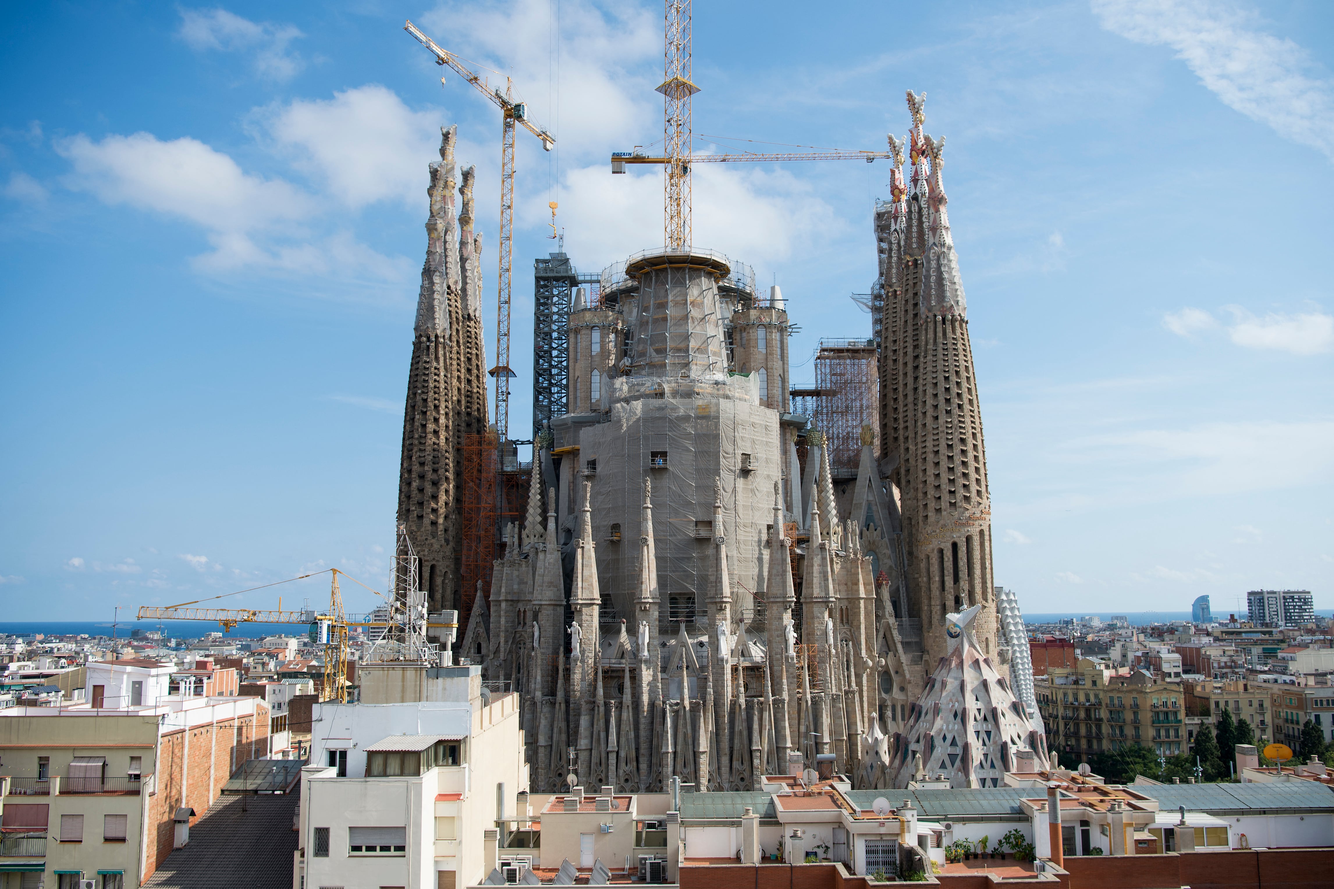 People watch a light show projected on the facade of Spanish architect Antoni Gaudi's Sagrada Familia Basilica, marking the start of the Holy Week, in Barcelona on April 14, 2025. The Catholic Church has put Antoni Gaudi, the designer of Barcelona's Sagrada Familia basilica nicknamed "God's architect", on the path to sainthood, the Vatican said today. Pope Francis recognised the Catalan architect's "heroic virtues" and authorised a decree declaring him "venerable", the Vatican said in a statement. (Photo by LLUIS GENE / AFP)