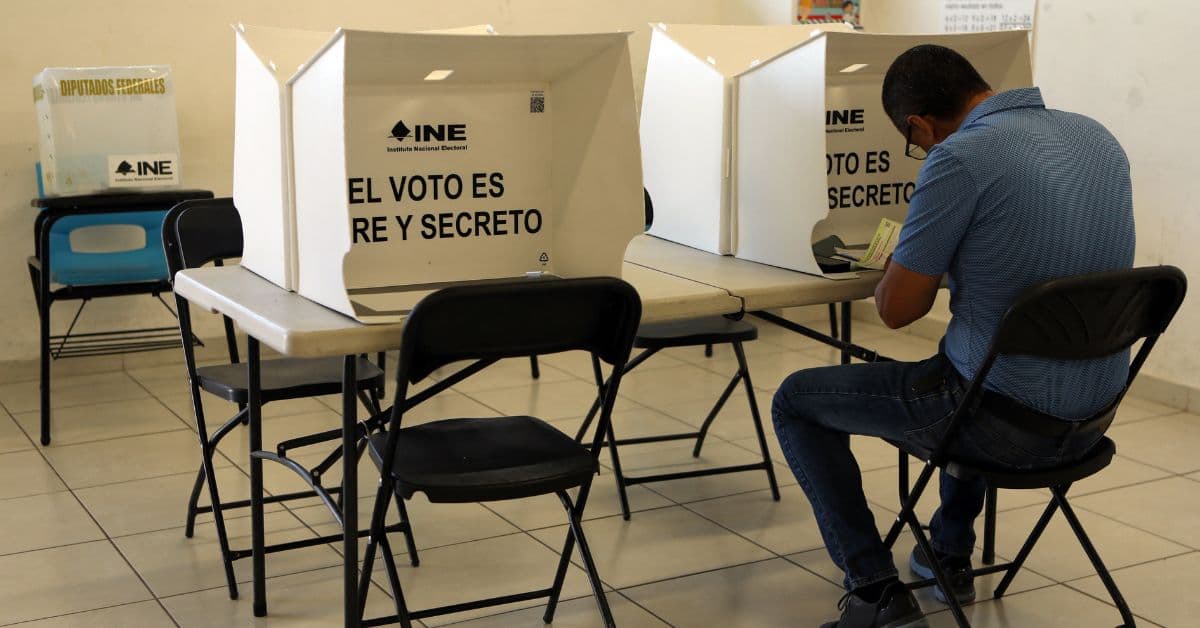 En la imagen alguien votando en los comisionados de México