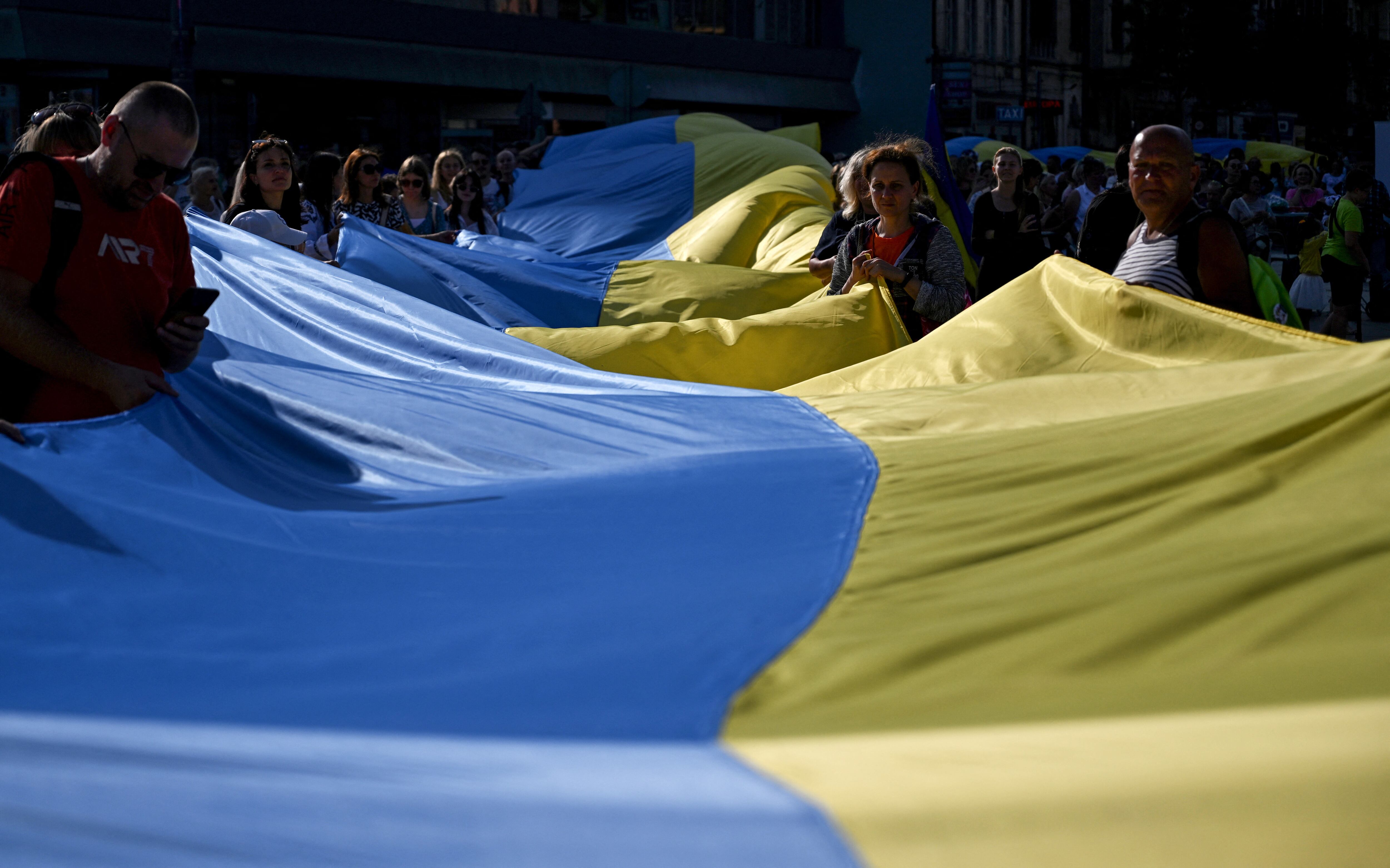 Miembros de la diáspora ucraniana despliegan una bandera ucraniana de 100 metros para conmemorar el Día de la Independencia de Ucrania en Katowice, región de Silesia, el 24 de agosto de 2024. (Foto de Sergei GAPON / AFP)