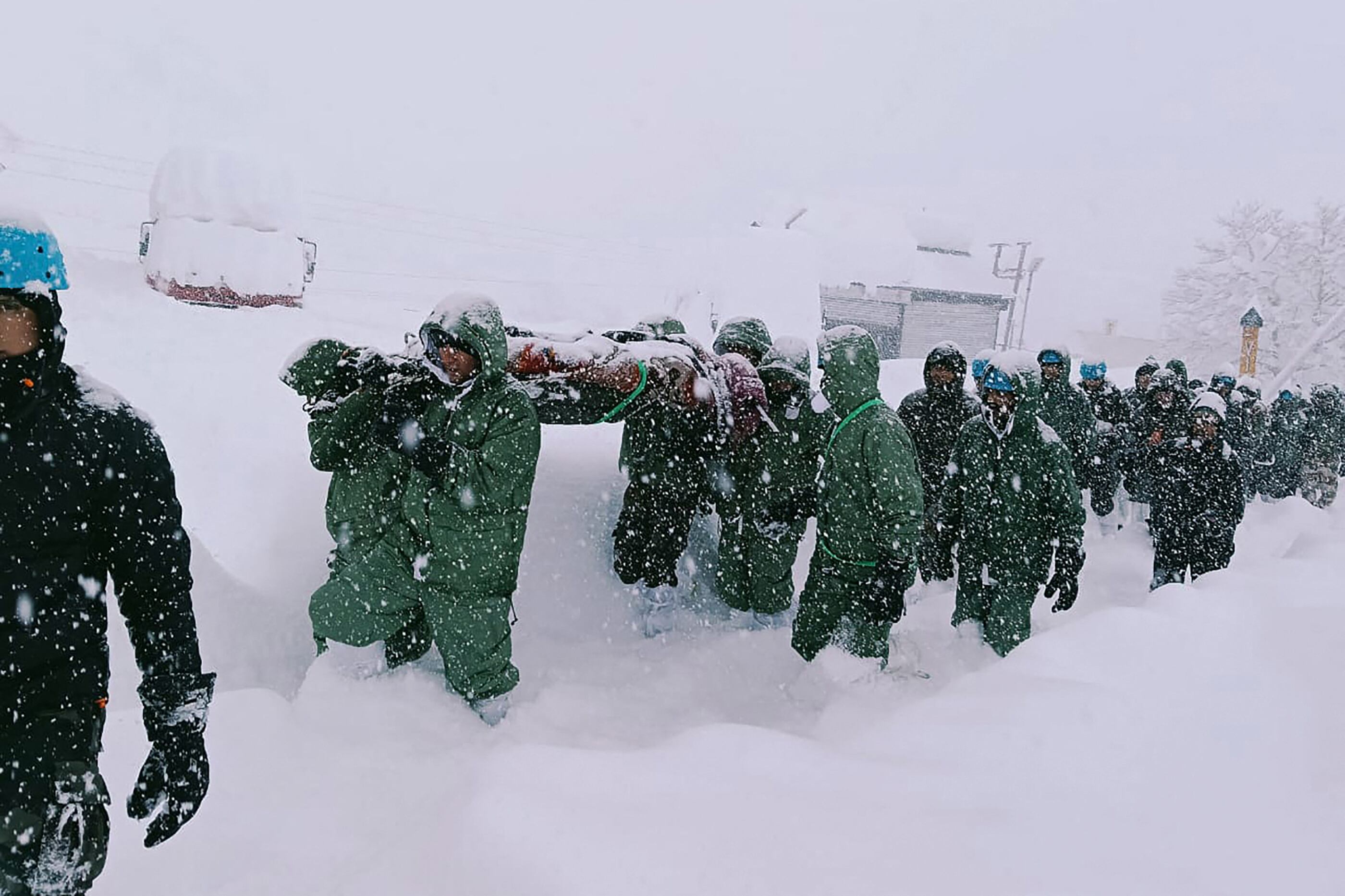 In this handout photo taken and released by the State Disaster Response Force (SDRF) on February 28, 2025, rescuers carry Border Roads Organisation (BRO) workers after an avalanche near Mana village in Chamoli district. Over 40 construction workers were missing while 15 others were rescued afte