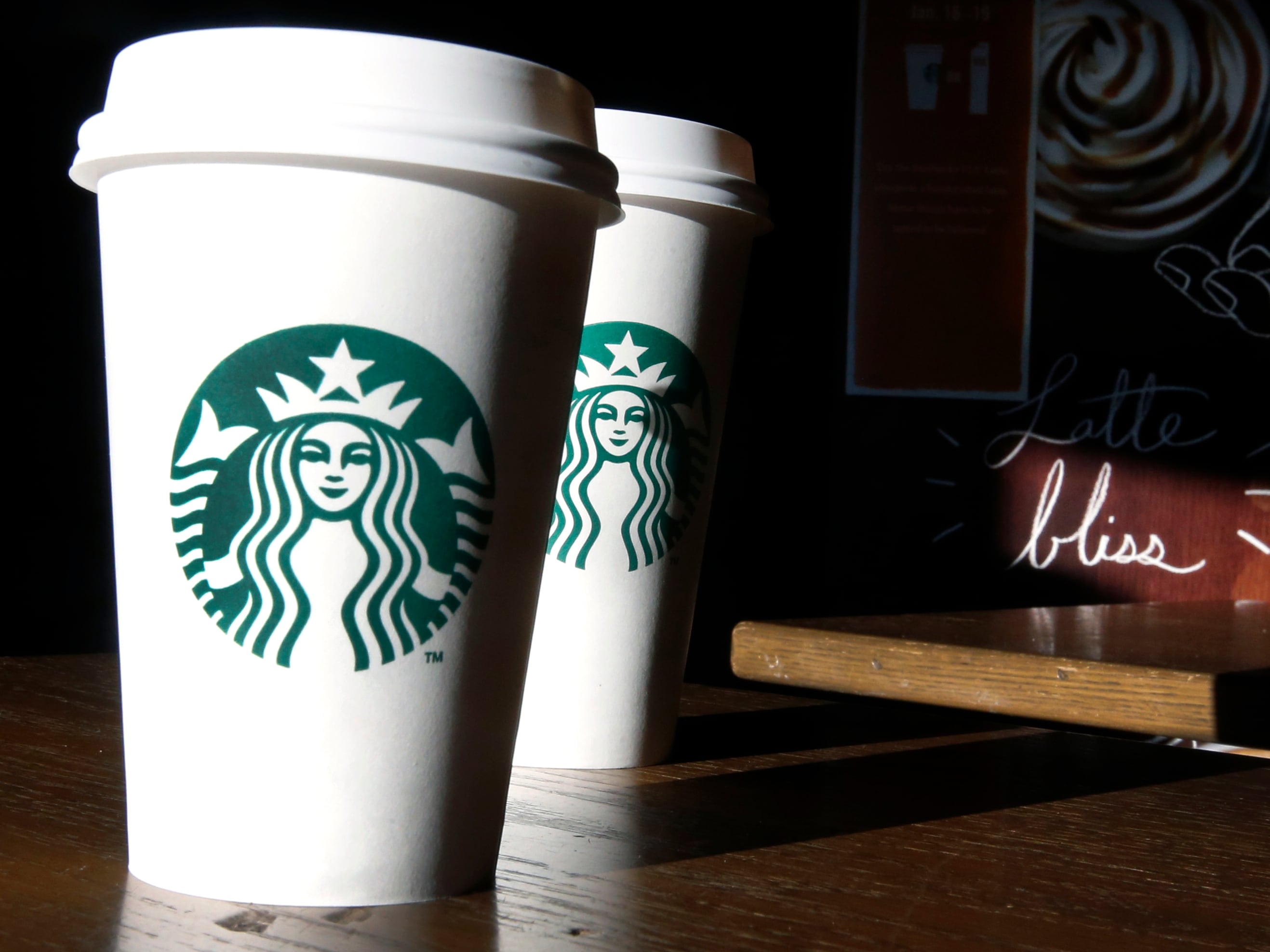 FILE - In this this Friday, Jan. 17, 2014, file photo, Starbucks cups are shown mugs in a cafe in North Andover, Mass. A federal judge in San Francisco ruled on Friday, June 17, 2016, that a lawsuit claiming the Seattle-based coffee chain under fills its lattes can move forward. (AP Photo/Elise Amendola, File)