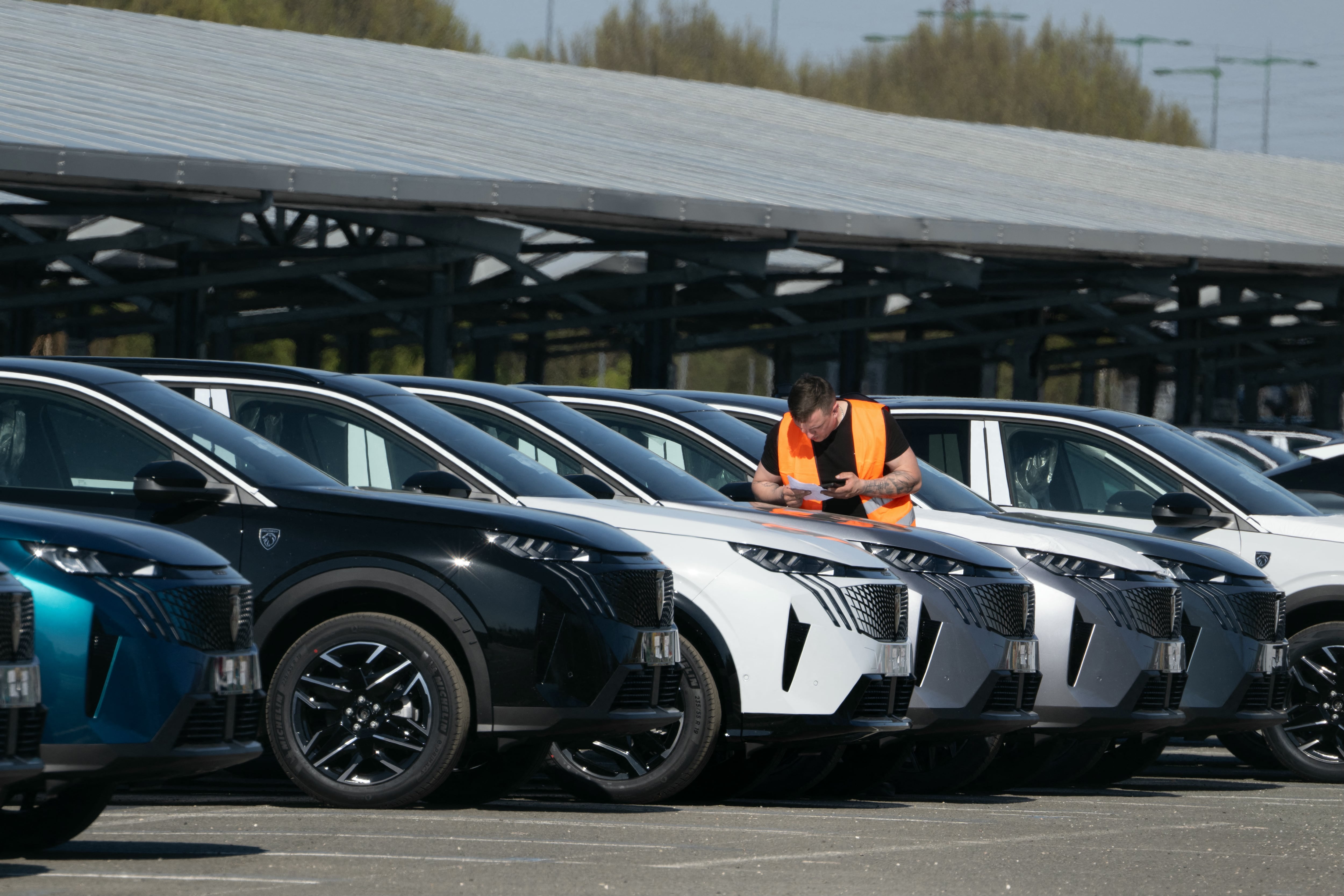 Un empleado revisa unos Peugeot 3008 III en el aparcamiento de la planta del fabricante de automóviles Stellantis en Sochaux, el 4 de abril de 2025. El fabricante de automóviles Stellantis está retirando del mercado 700 000 vehículos en todo el mundo por riesgo de incendio, incluidos coches de las marcas Peugeot, Citroën, Fiat, Alfa Romeo y Jeep, según la página web de la Autoridad Federal Alemana de Transporte Motorizado (KBA), con más de 50 000 vehículos afectados en Alemania. Stellantis, que solo se comunica país por país, declaró el 1 de abril de 2026 que la retirada afectaba a 212 000 vehículos fabricados entre 2023 y 2026 en Francia, más de la mitad de ellos modelos Peugeot, tras registrarse 36 incidentes relacionados con el problema en todo el mundo, incluidos 12 casos de incendio.