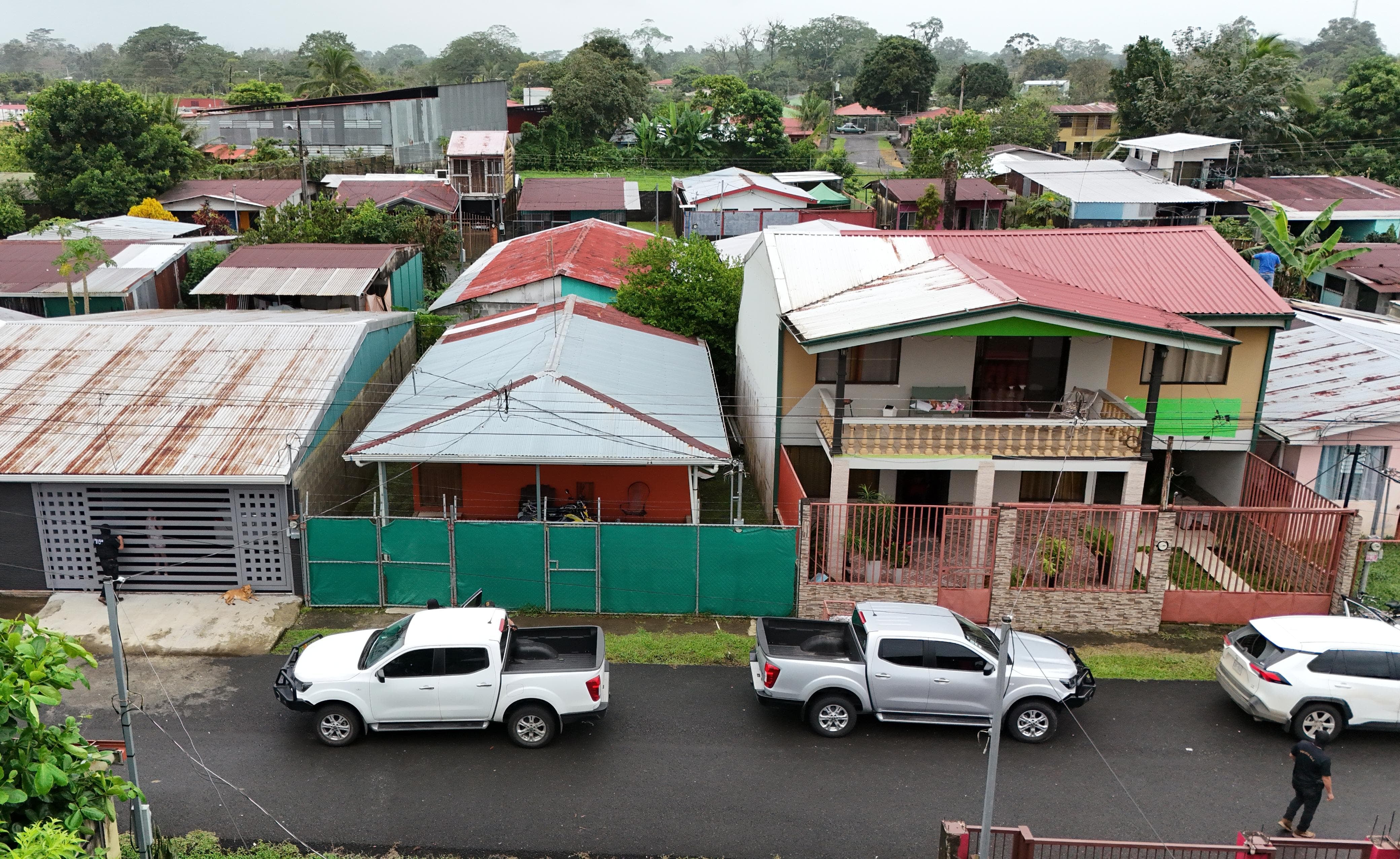 La casa con sarán verde en Pueblo Nuevo de La Rita fue allanada por el OIJ este sábado en la búsqueda de uno de los sospechosos de disparar y dejar grave a Geiner Zamora, subjefe local del OIJ. Foto: Reiner Montero.