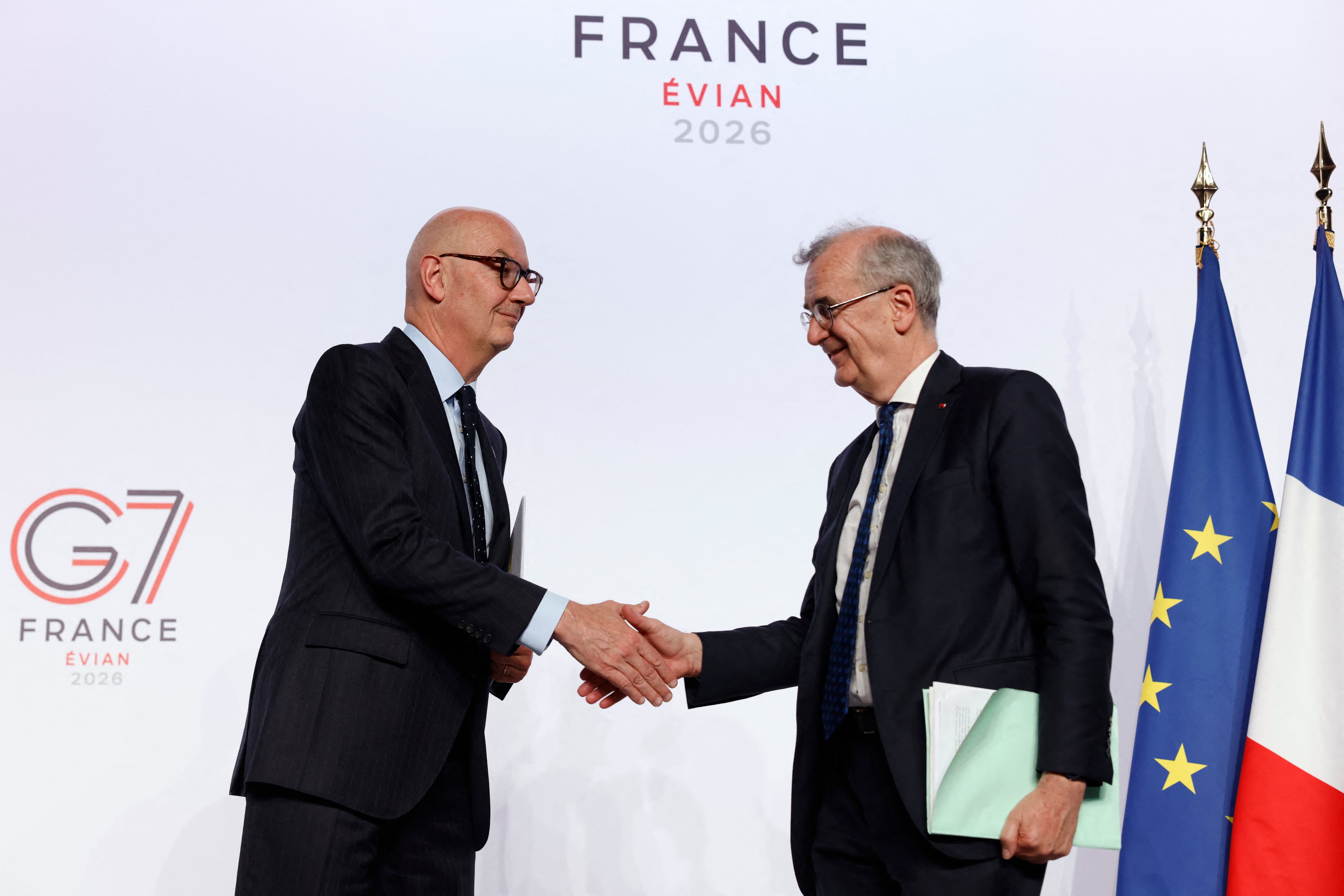 El ministro francés de Economía, Finanzas e Industria, Roland Lescure, estrecha la mano del gobernador del Banco de Francia, François Villeroy de Galhau