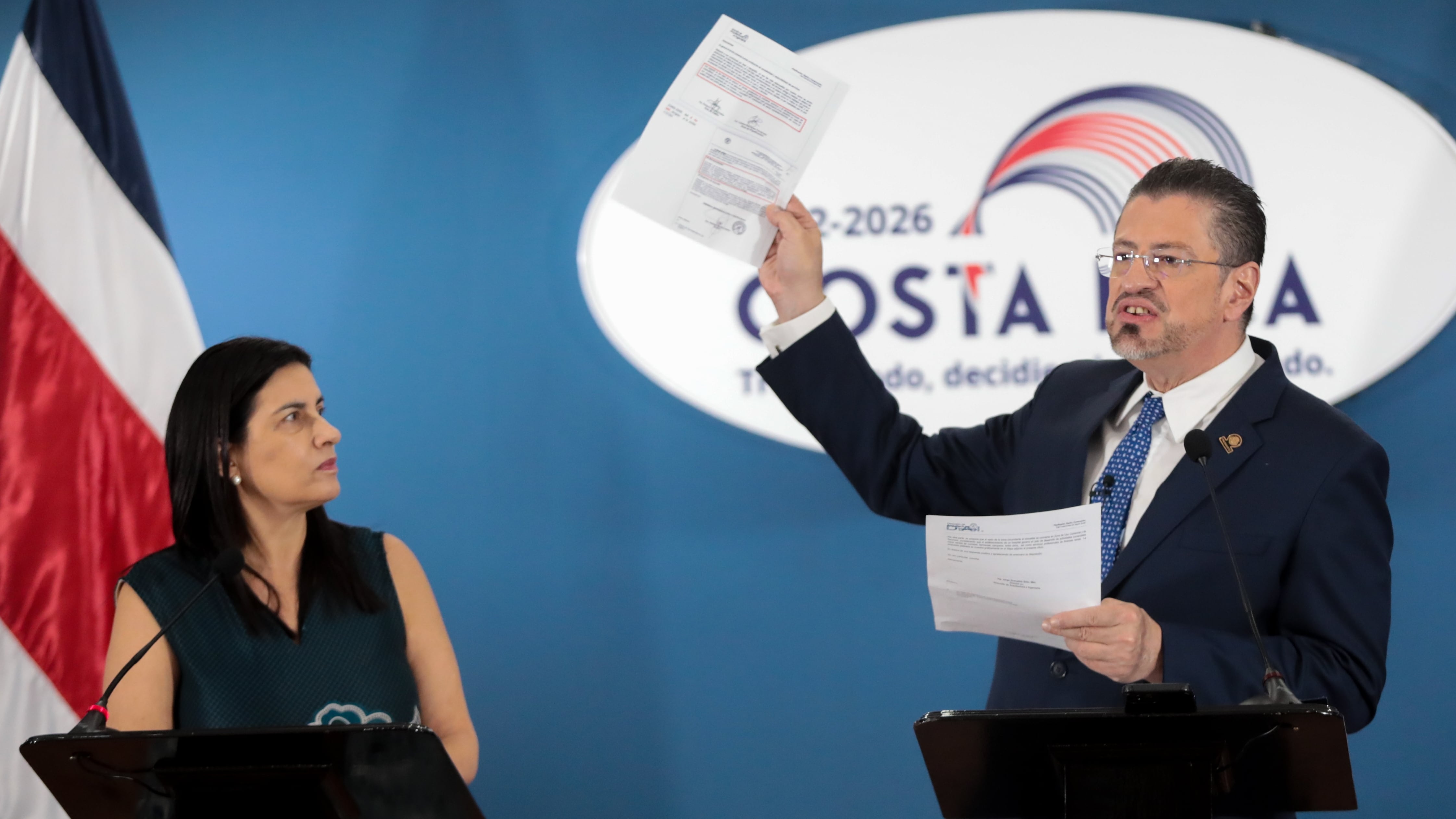El presidente Rodrigo Chaves sostiene unos documentos mientras habla en la conferencia de prensa de Casa Presidencial, acompañado por la entonces presidenta ejecutiva de la CCSS, Marta Eugenia Esquivel.