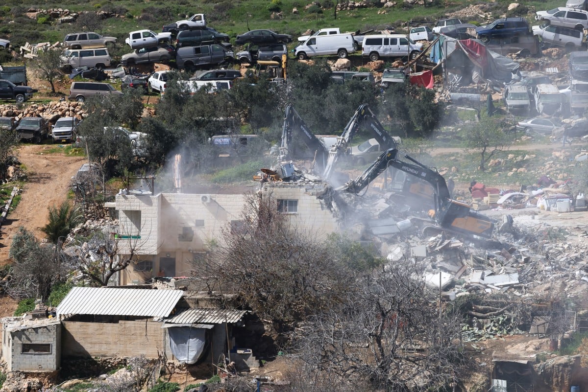 Excavadoras israelíes demuelen un edificio de apartamentos perteneciente a la familia Salhab cerca del asentamiento israelí de Hagai, al sur de la ciudad de Hebrón, en la Cisjordania ocupada.