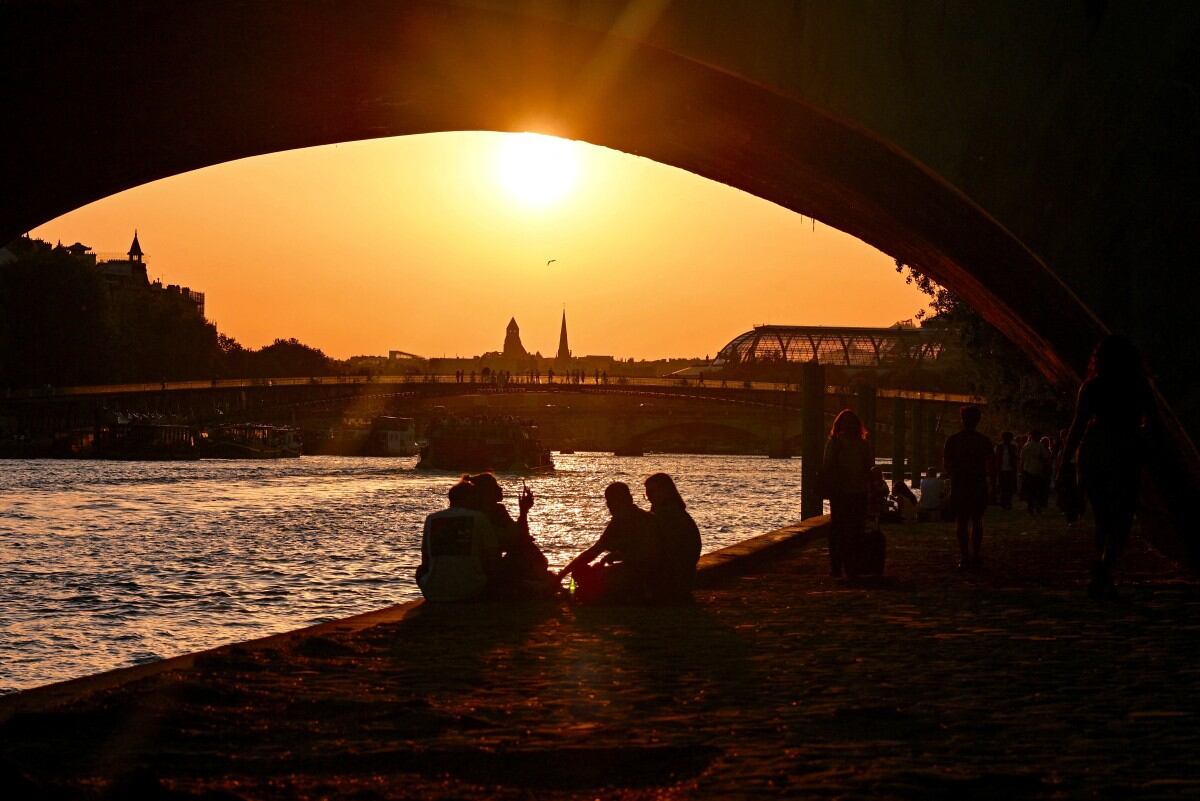 Personas disfrutan del atardecer a orillas del río Sena en París, el 1 de mayo de 2025. Ese día, las temperaturas superaron los 29 °C en la capital francesa, batiendo el récord anterior de 28,7 °C registrado en 2005.
(Foto de Christophe DELATTRE / AFP)