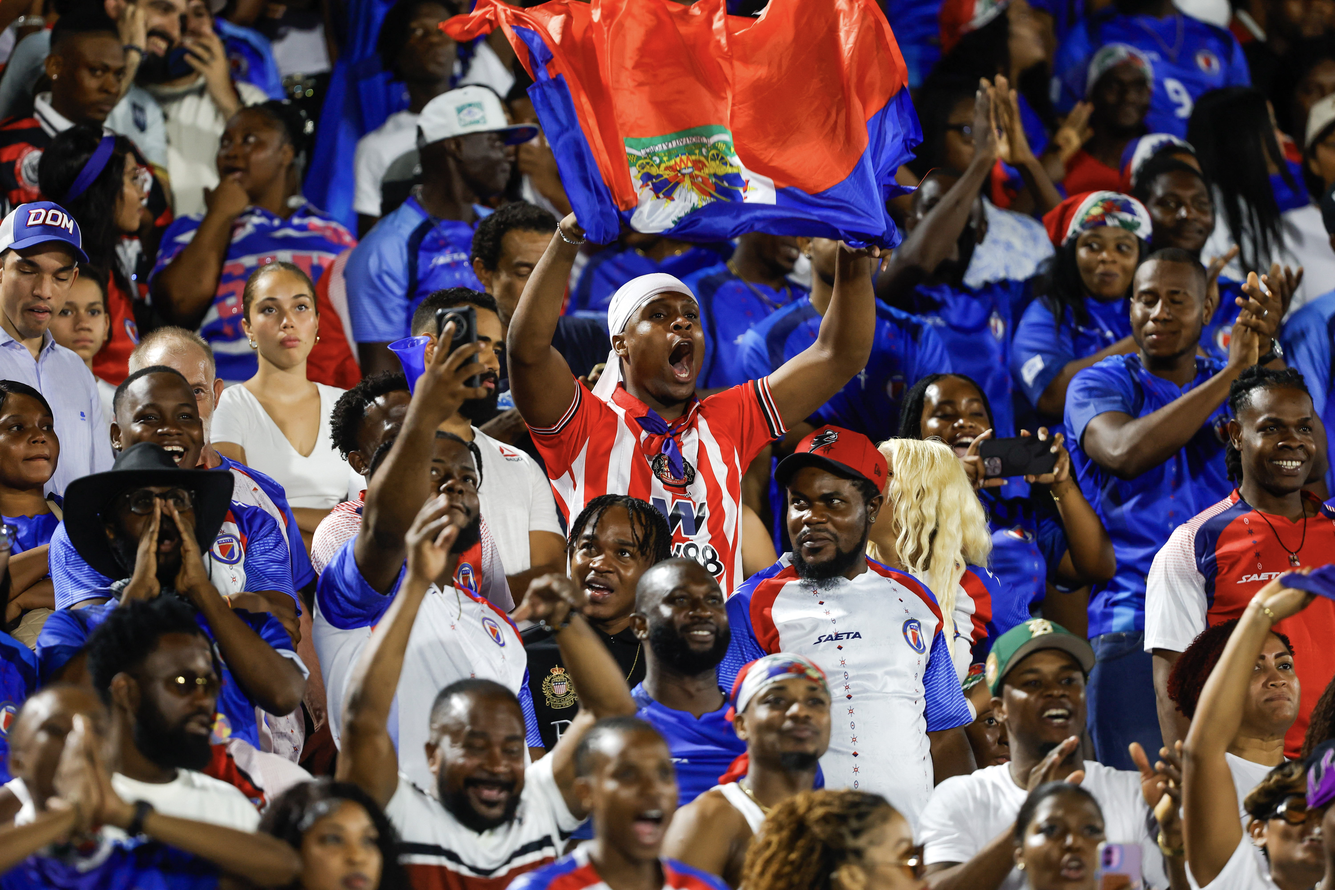 Aficionados haitianos celebran en la gradería del estadio Félix Sánchez de Santo Domingo, en la victoria ante República Dominicana por la Nations League de Concacaf el 1.° de octubre.