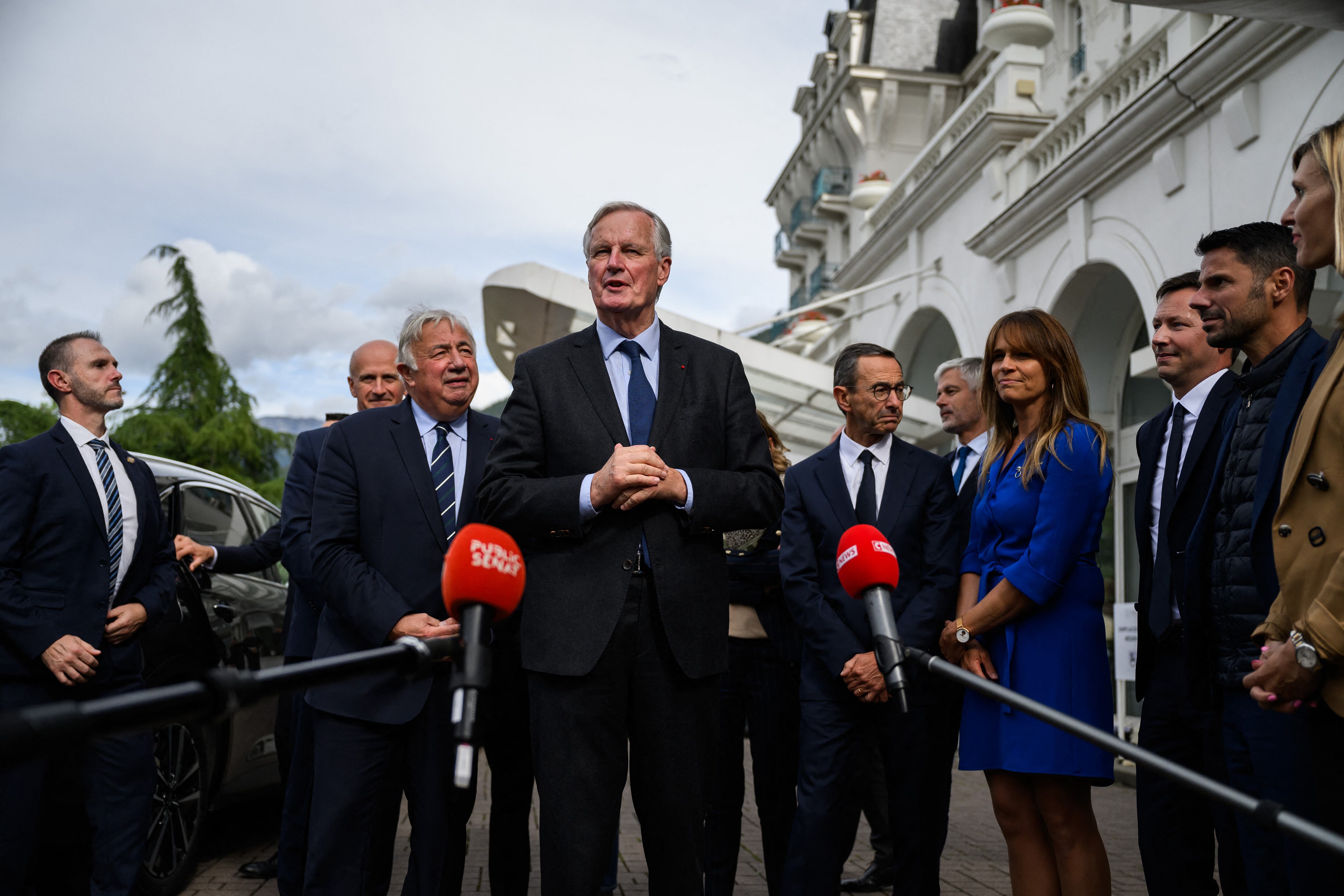 El primer ministro francés, Michel Barnier (centro), habla con los periodistas después de ser recibido por el jefe del grupo parlamentario del partido Les Republicains.