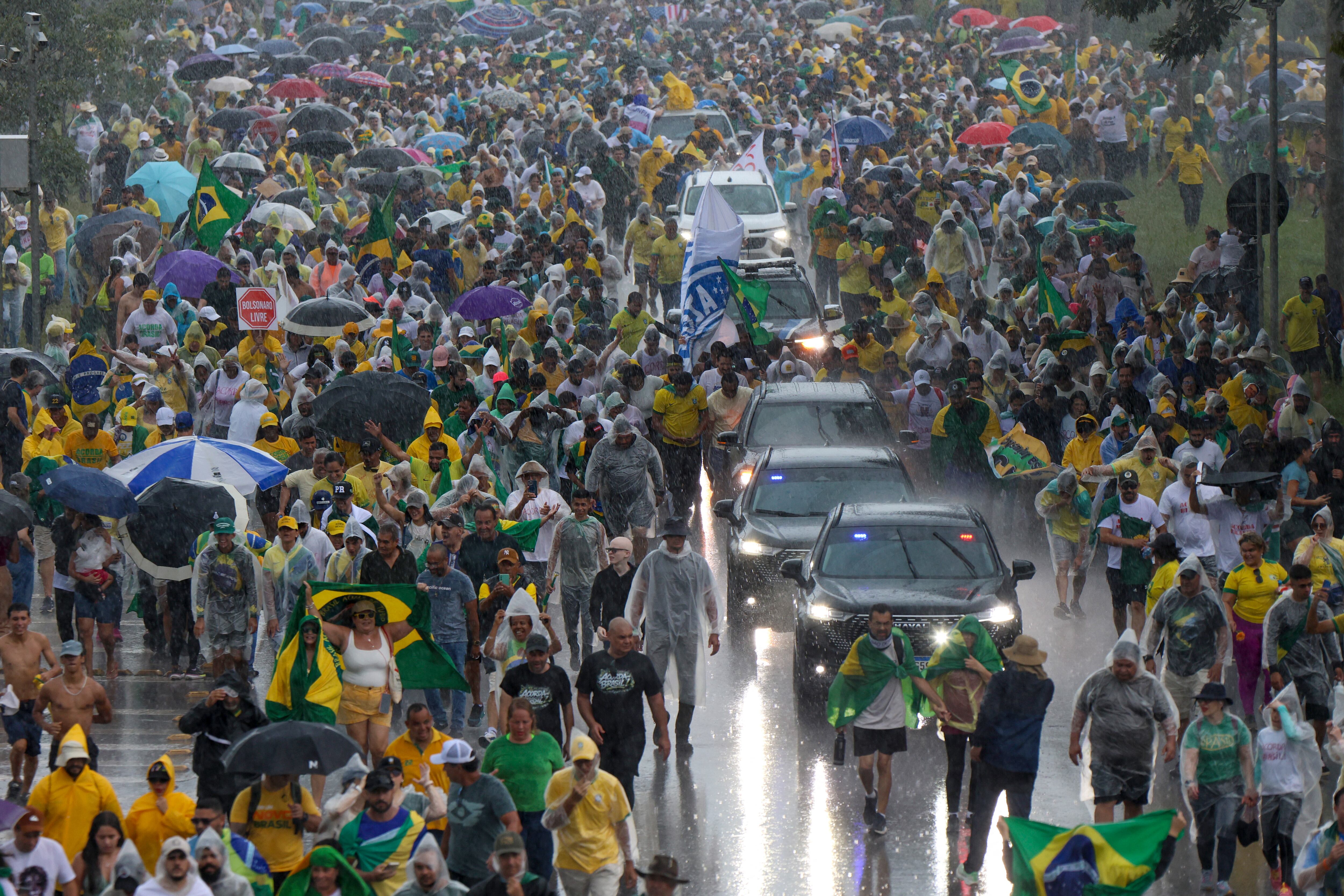 Seguidores de Nikolas Ferreira y Jair Bolsonaro caminan bajo la lluvia en Brasilia durante una marcha que exigía amnistía para Bolsonaro, cuando un rayo dejó 30 heridos.