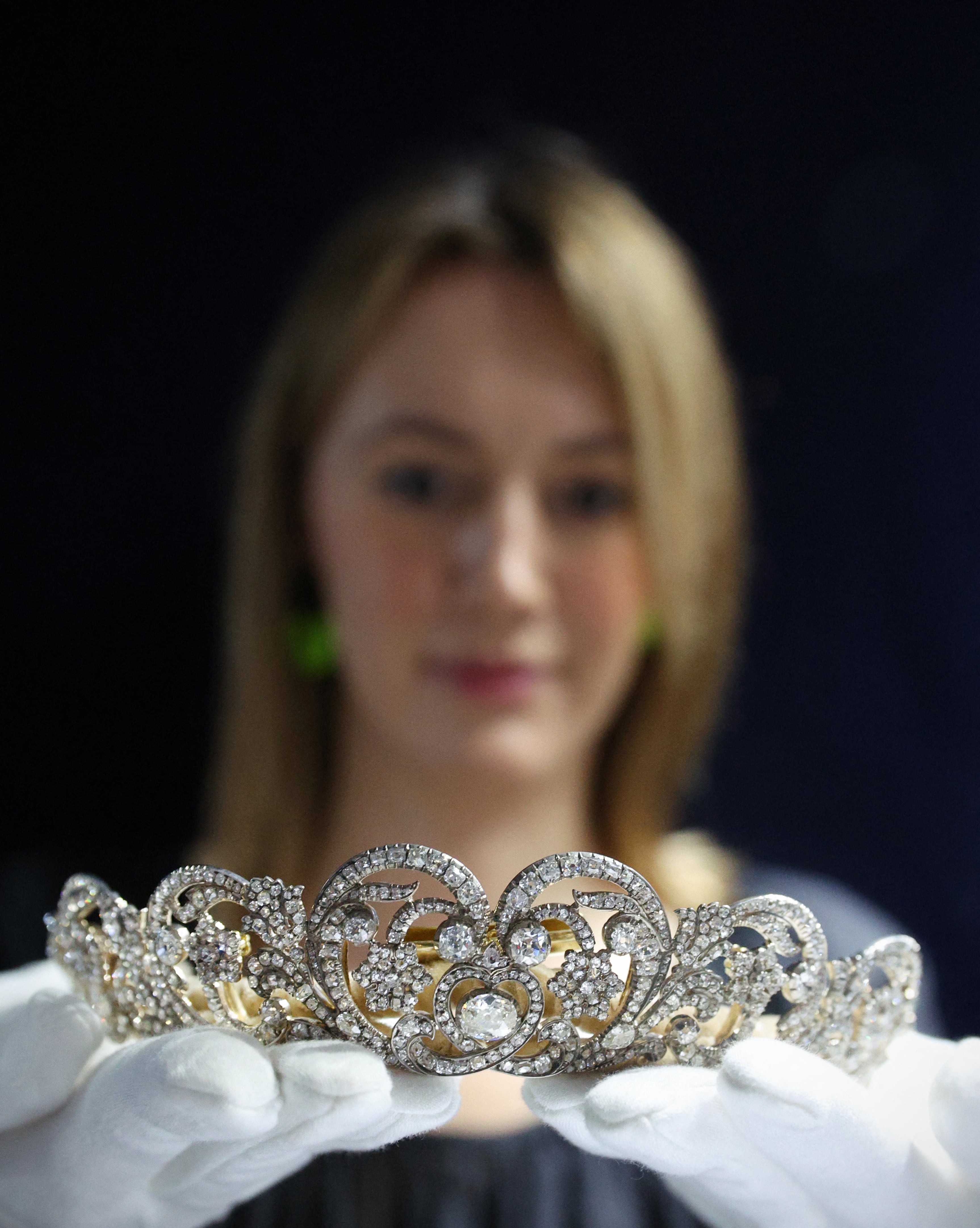 Un empleado de Sotheby's sostiene la «Tiara Spencer», la misma que lució la princesa Diana el día de su boda en 1981, durante una sesión fotográfica para promocionar la Temporada del Jubileo de Sotheby's, en el centro de Londres, el 27 de mayo de 2022. «Retratos y poder», una exposición itinerante en Sotheby's, abarca desde la época de los Tudor hasta la actualidad. La muestra destaca los cinco siglos en los que las monarcas han utilizado el arte para influir e impresionar a sus súbditos.
