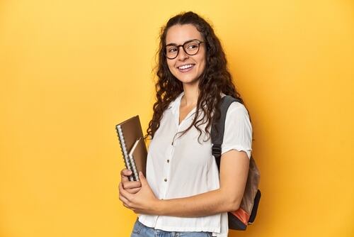 Joven estudiante con gafas, mochila y cuaderno, simbolizando el empoderamiento juvenil en Costa Rica al priorizar su educación y desarrollo personal, alejándose de la maternidad temprana.