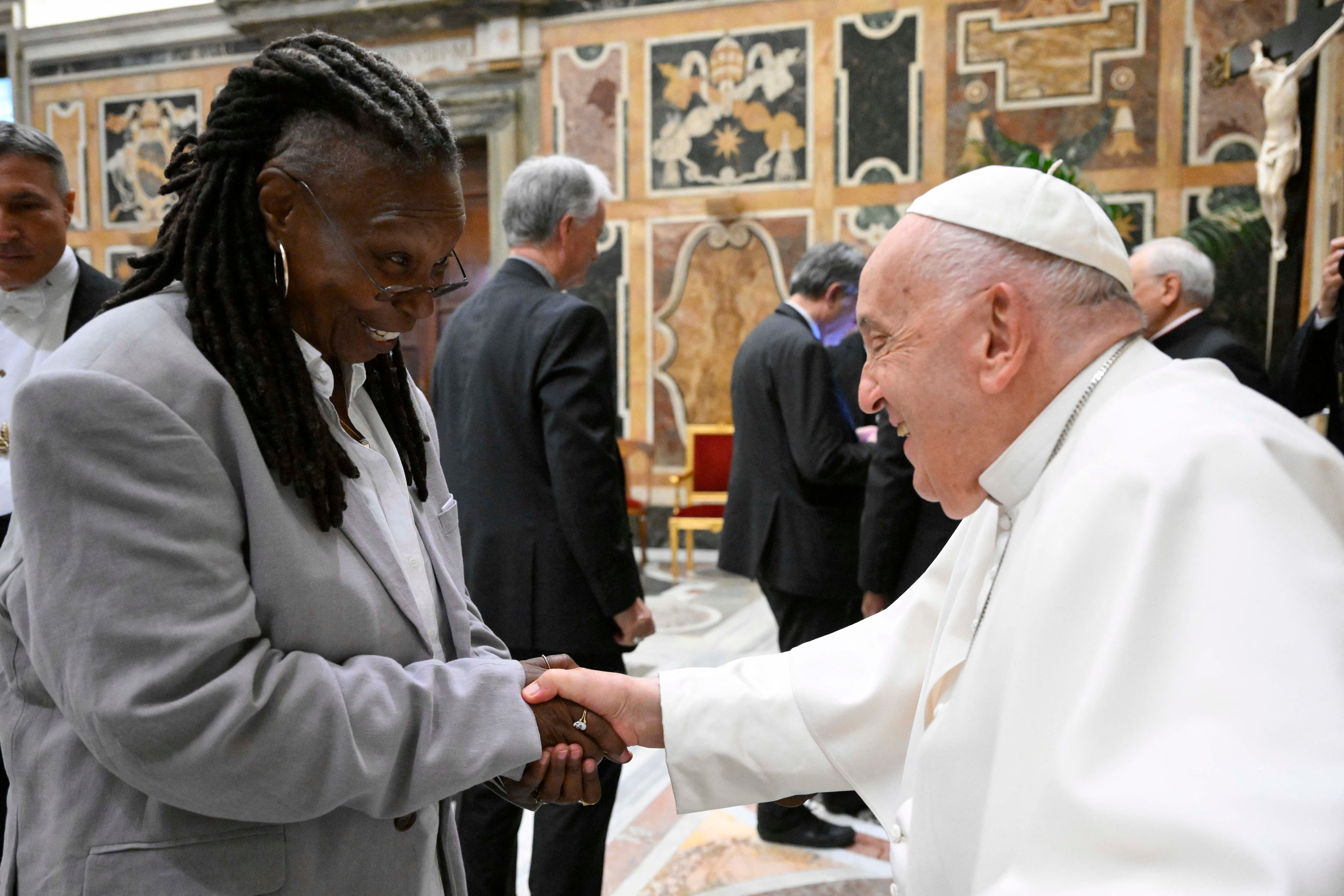 This photo taken and handout on June 14, 2024 by The Vatican Media shows Pope Francis shaking hand with US actress Whoopi Goldberg as part of an audience with comedians in The Vatican. (Photo by Simone Risoluti / VATICAN MEDIA / AFP) / RESTRICTED TO EDITORIAL USE - MANDATORY CREDIT "AFP PHOTO / VATICAN MEDIA" - NO MARKETING - NO ADVERTISING CAMPAIGNS - DISTRIBUTED AS A SERVICE TO CLIENTS