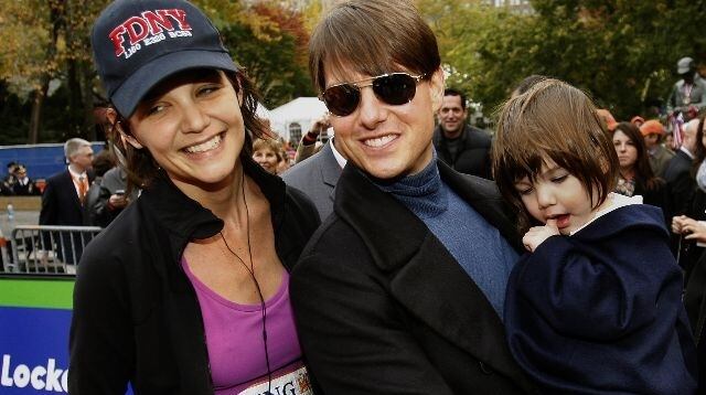 US actor Tom Cruise holding his daughter Suri greets his wife Katie Holmes after she finished running the New York City Marathon in New York 04 November 2007. AFP PHOTO/TIMOTHY A. CLARY