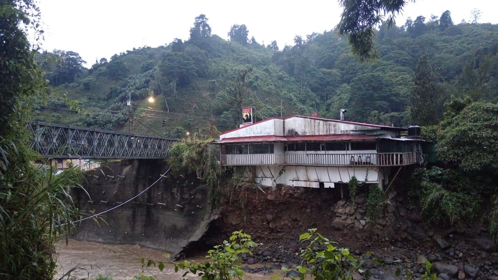 Este puente bailey sobre el río Navarro, conocido como Puente Negro, está apoyado en bases que deben ser revisadas. A su lado un local comercial quedó a punto de colapsar. Foto: Cortesía Valle de Orosi.