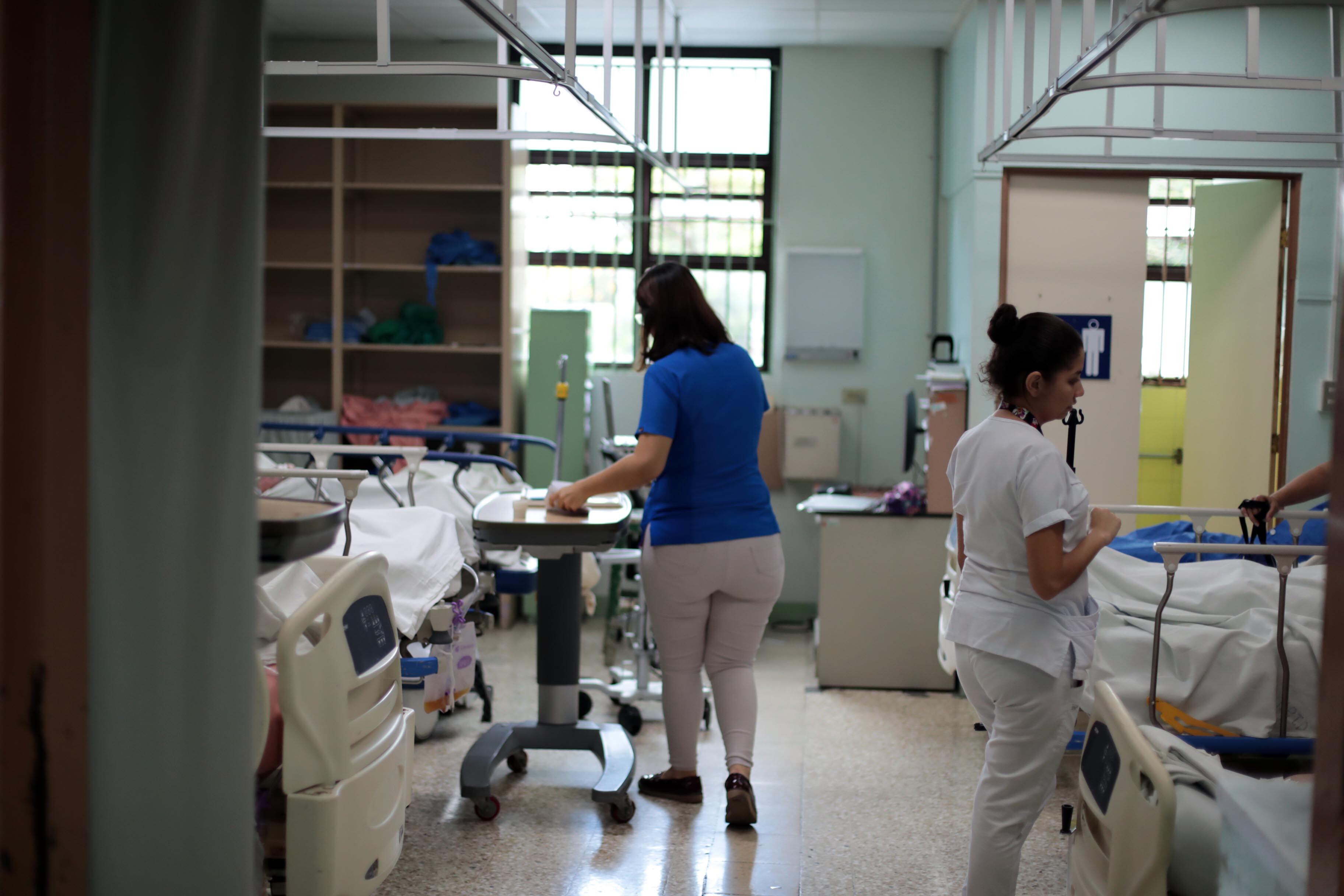 Un salón dentro de un hospital, no se distinguen las caras de las personas.