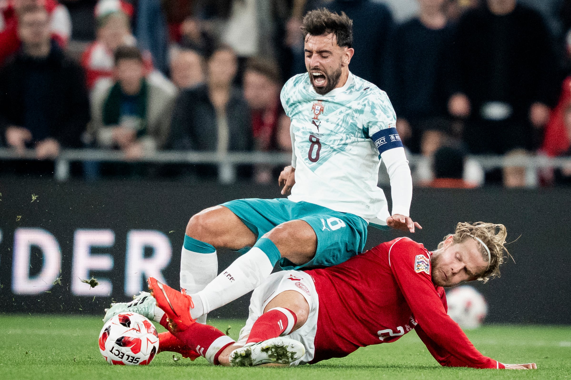 El capitán de la Selección de Portugal, Bruno Fernandes, recibe la embestida del danés Morten Hjulmand, en este compromiso de la Nations League de Europa donde los lusitanos no tuvieron a Cristiano Ronaldo.